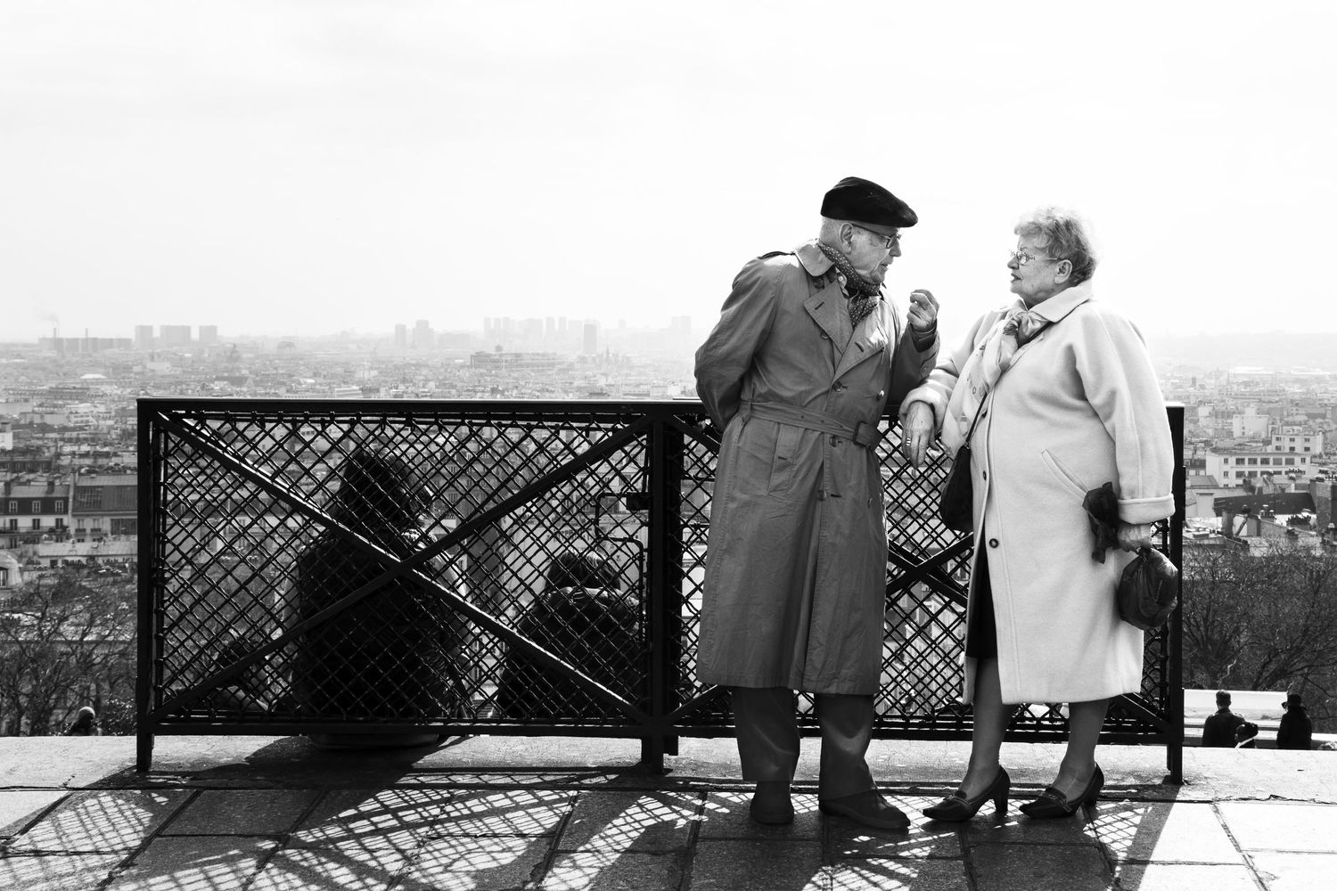 People enjoying panoramic city views from an observation deck in black and white.