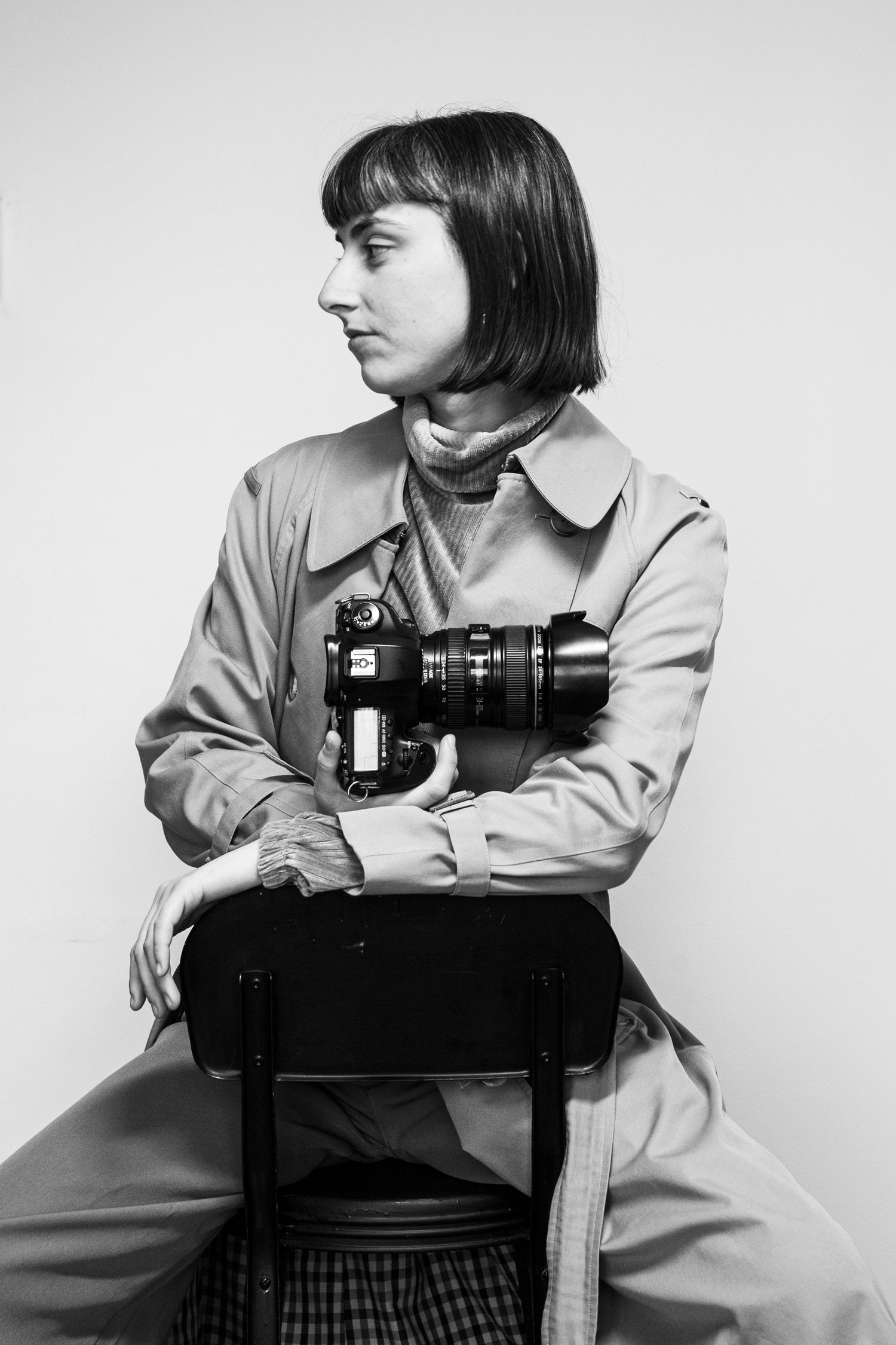 A side profile studio portrait in black and white featuring a photographer with camera.