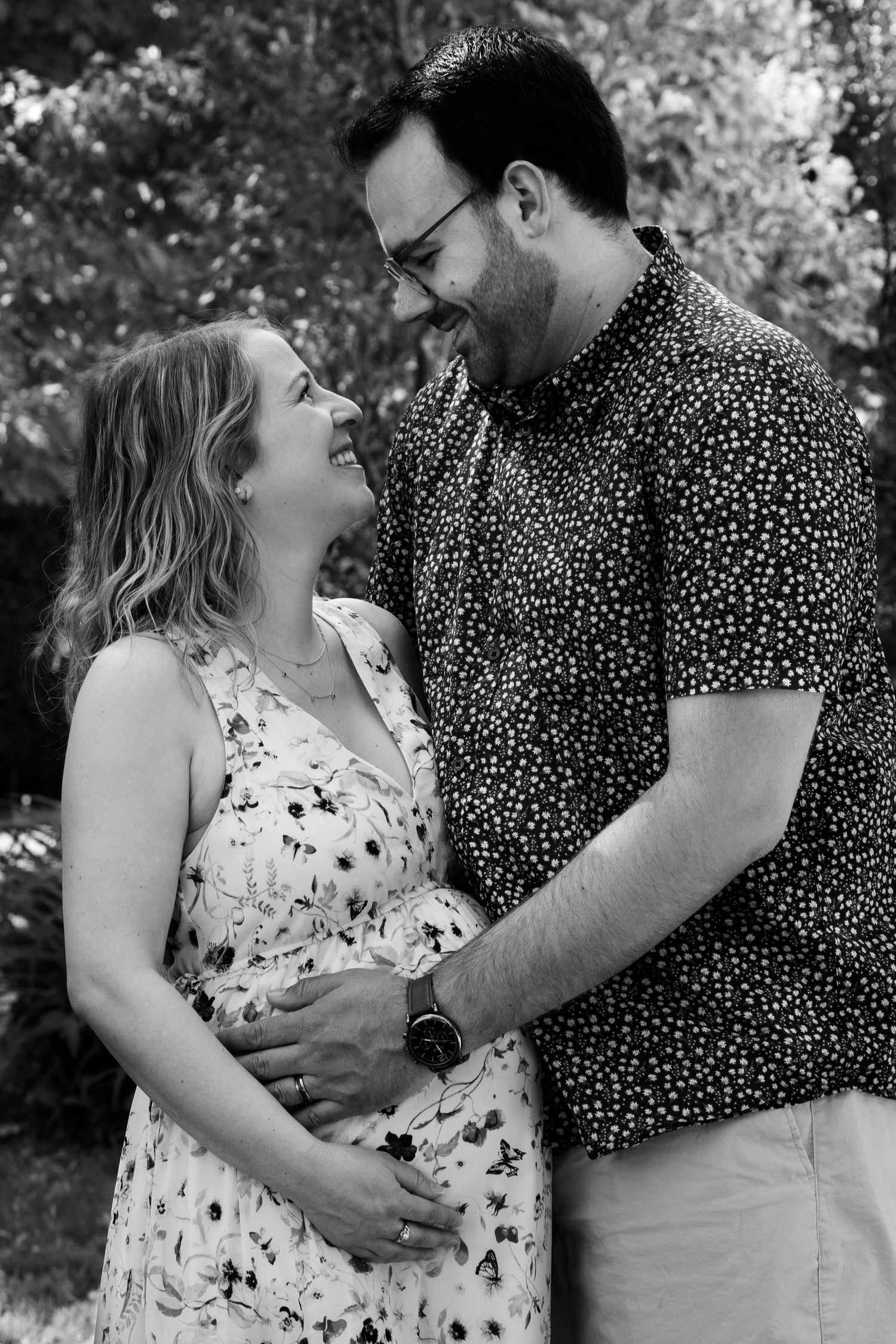 Outdoor maternity photoshoot with couple in floral and polka dot patterns.