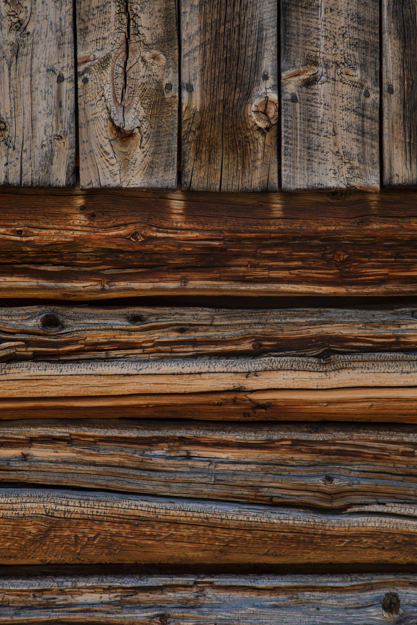 Weathered wooden wall texture showing rustic brown planks with natural grain patterns and knots.