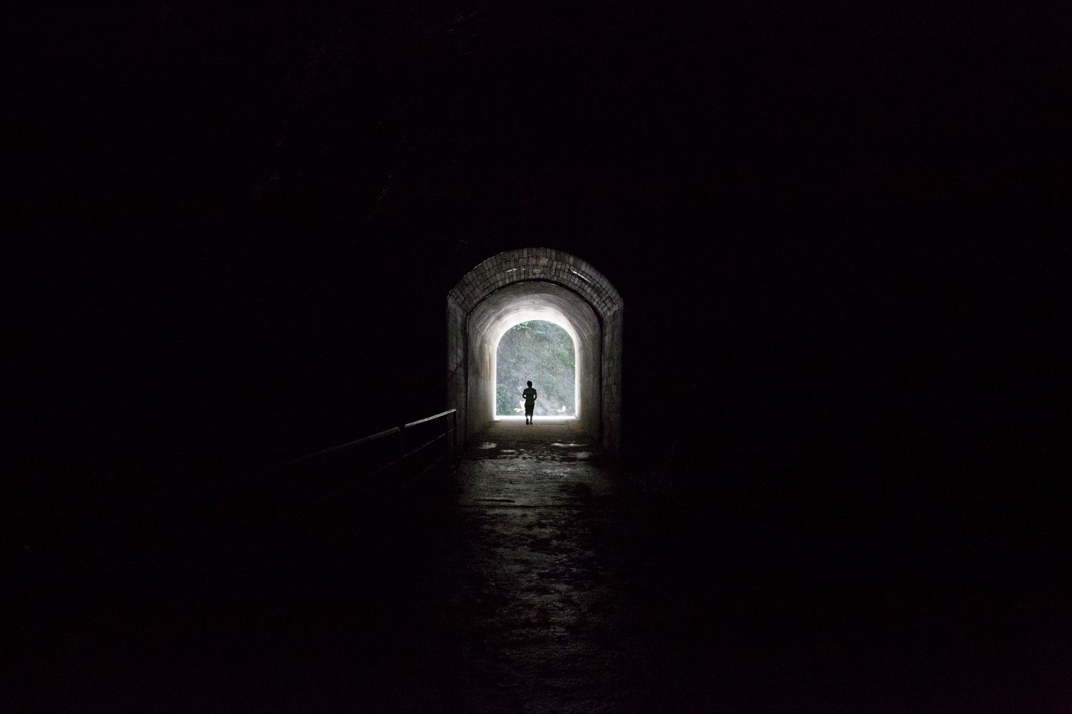 Dark tunnel with a small window of light at the end creating mysterious atmosphere.