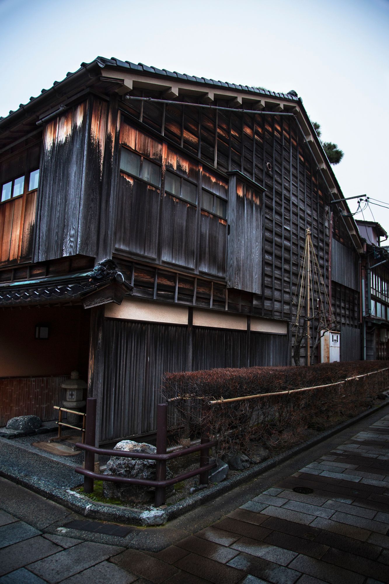Traditional Japanese wooden buildings with weathered facades at dusk.