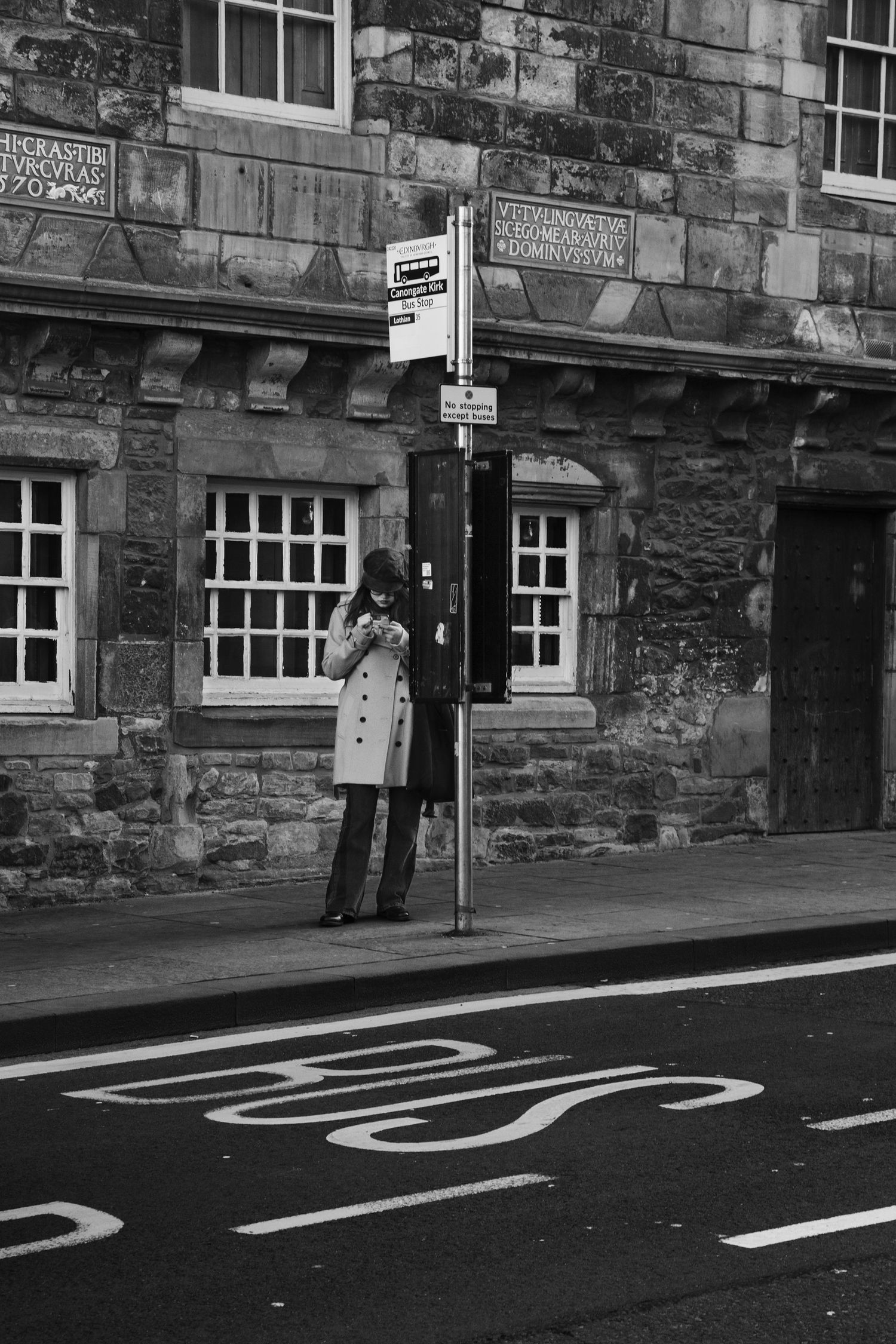 Historic stone building facade with painted road markings in black and white.