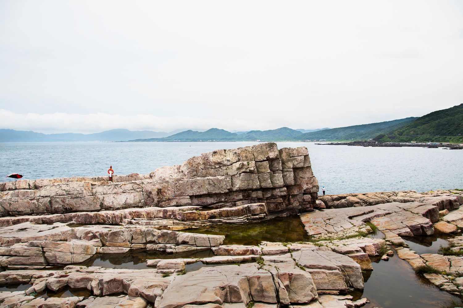 Rocky coastal landscape with jagged limestone formations stretching along the shoreline.