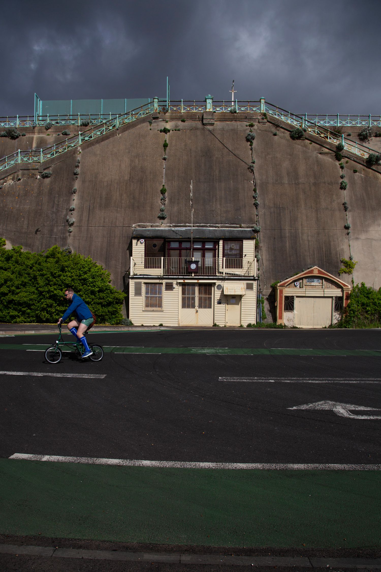 Panoramic view of a large concrete building with athletic courts in the foreground.
