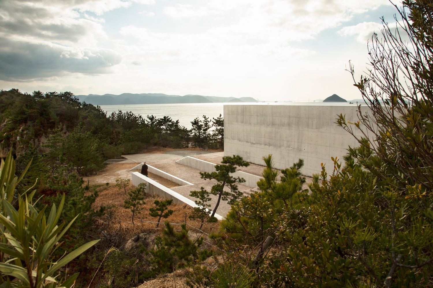 Panoramic view of a modern coastal development with mountains and water in the distance.