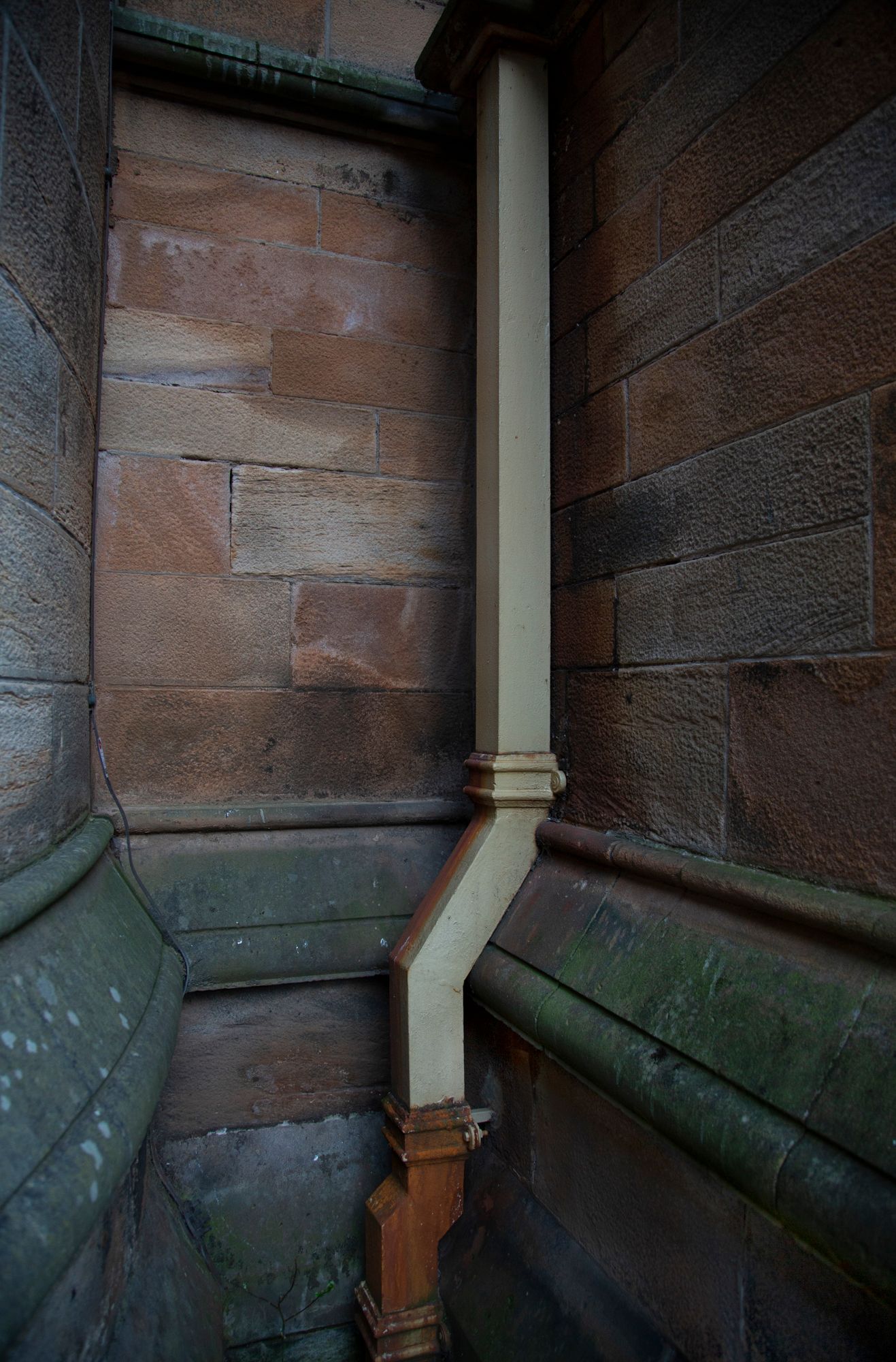 Architectural detail showing stone walls and columns with green trim in a historic building interior.