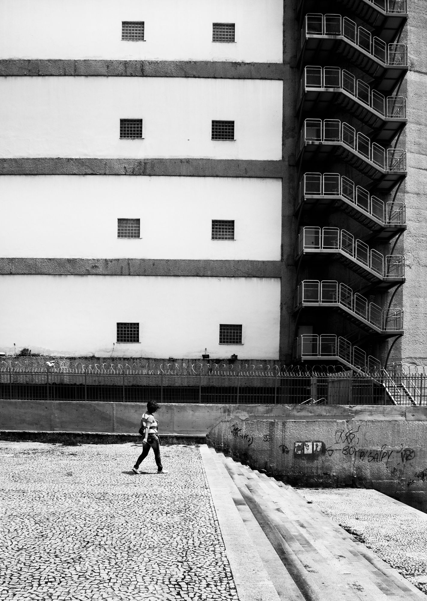 Minimalist black and white photo of industrial building with fire escape stairs.