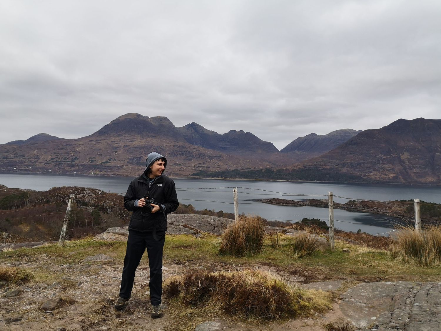 A scenic mountain landscape with a lake and cloudy skies in the Scottish Highlands.
