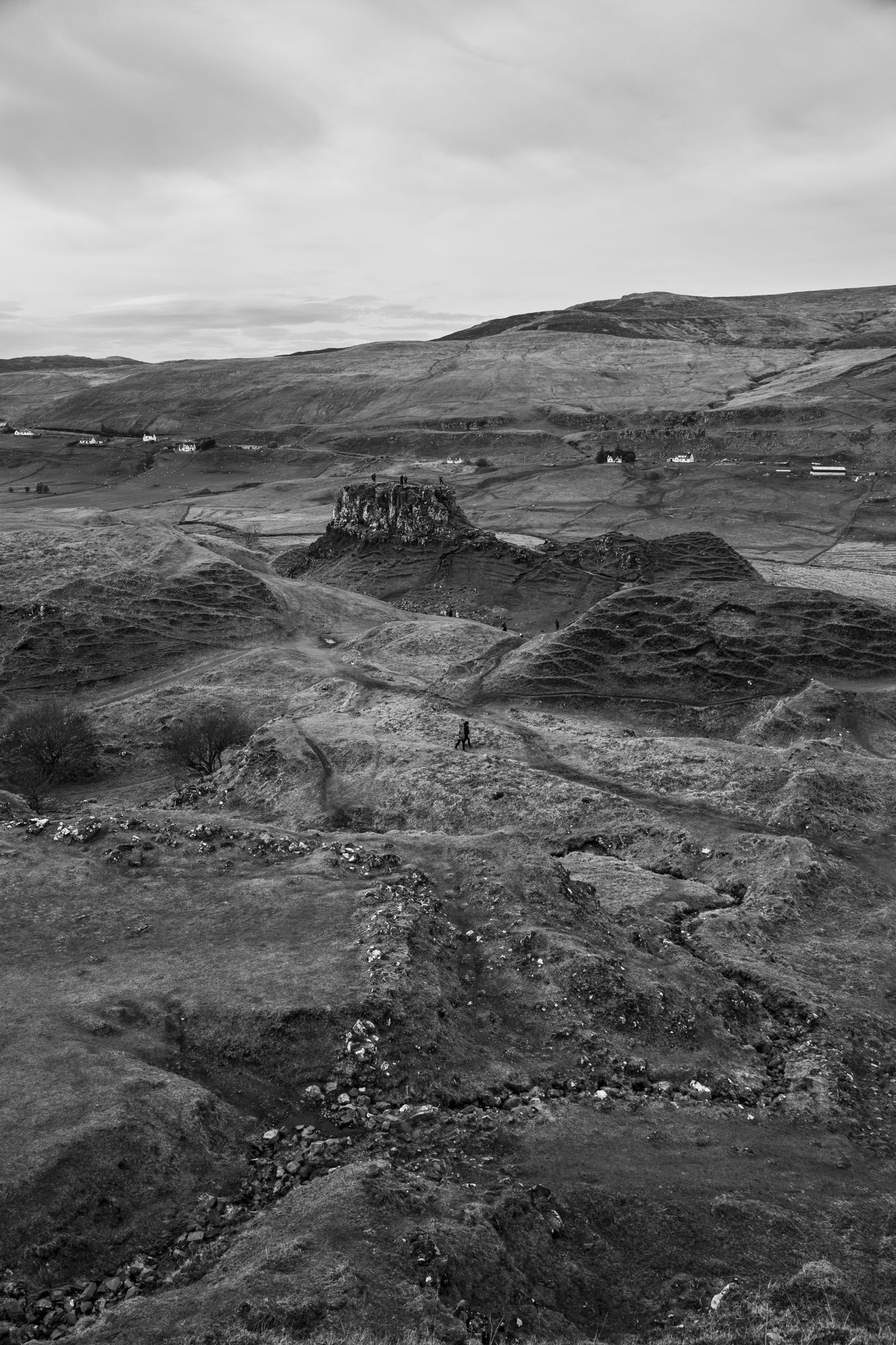A panoramic black and white view of rugged Scottish Highland terrain with rolling hills and scattered settlements.