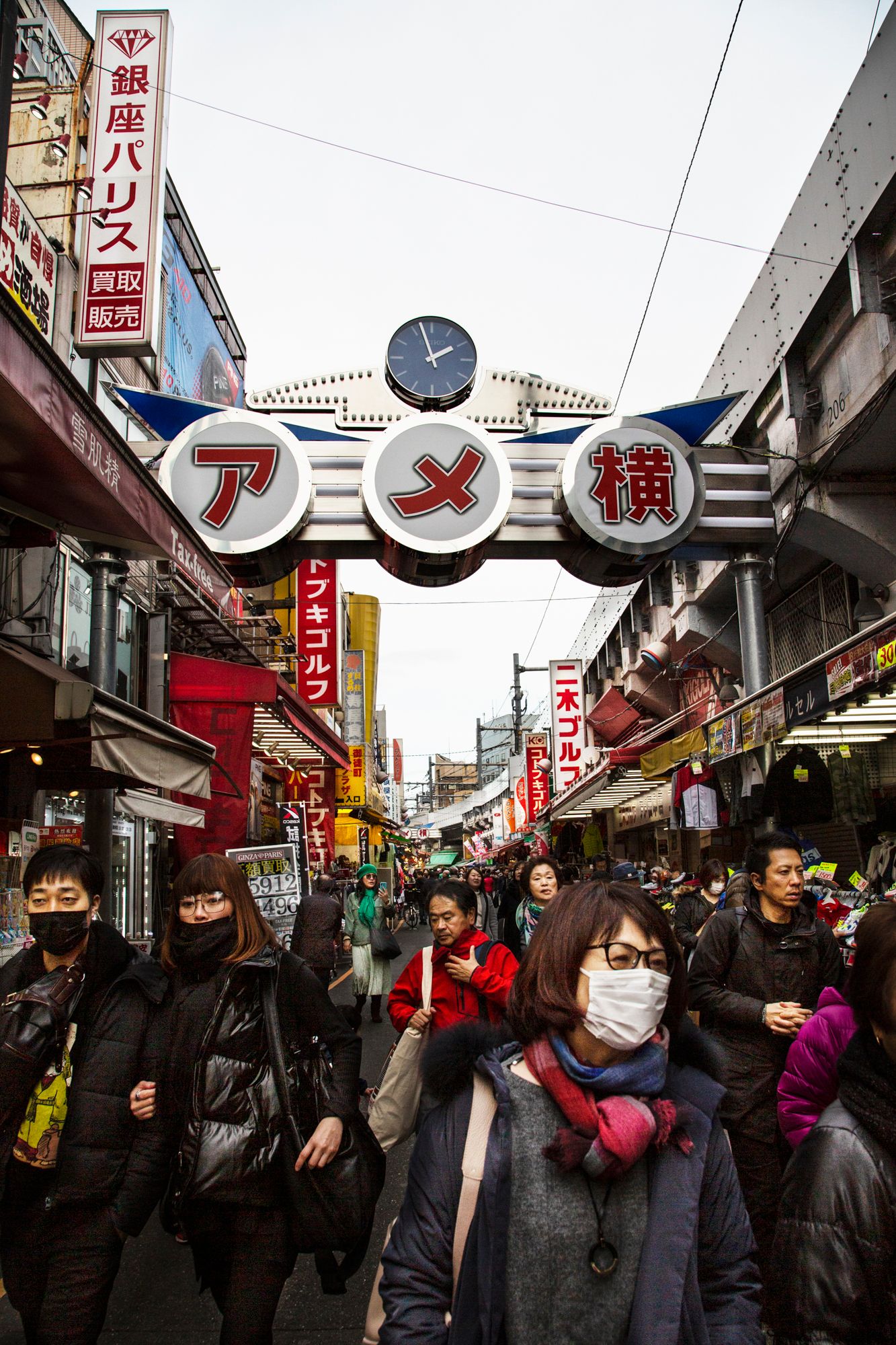 Busy shopping street in Japan with illuminated signs and storefronts.