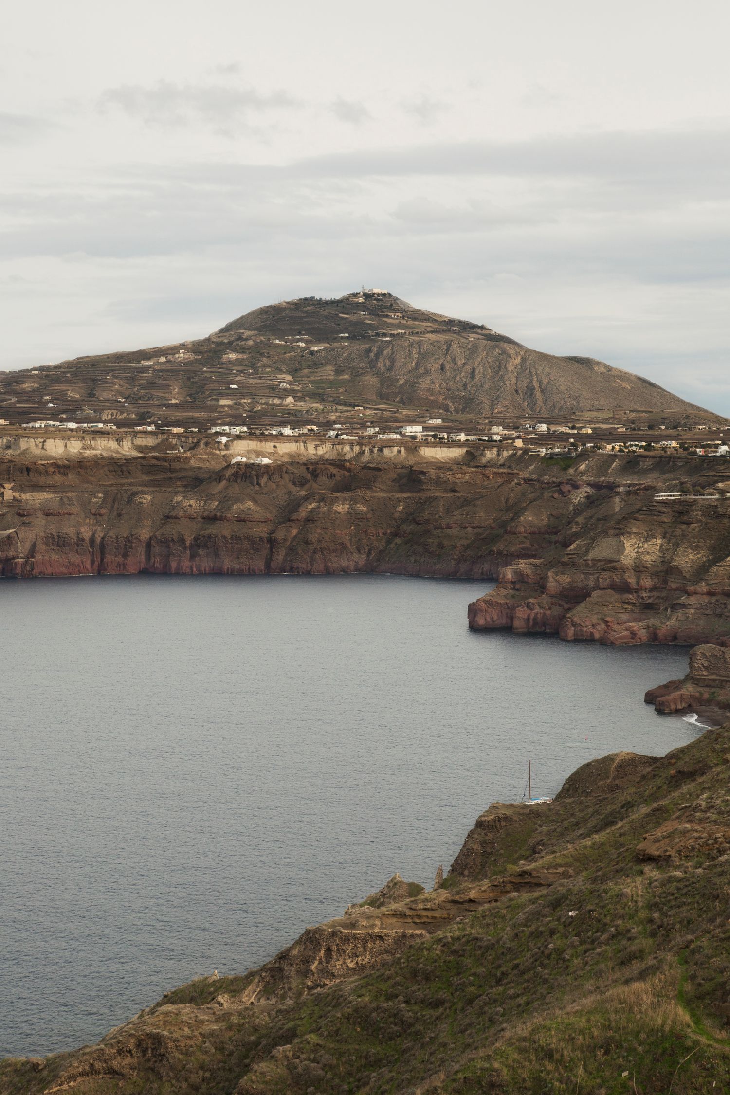 Coastal cliffs with settlements perched along the rocky Mediterranean coastline at sunset.