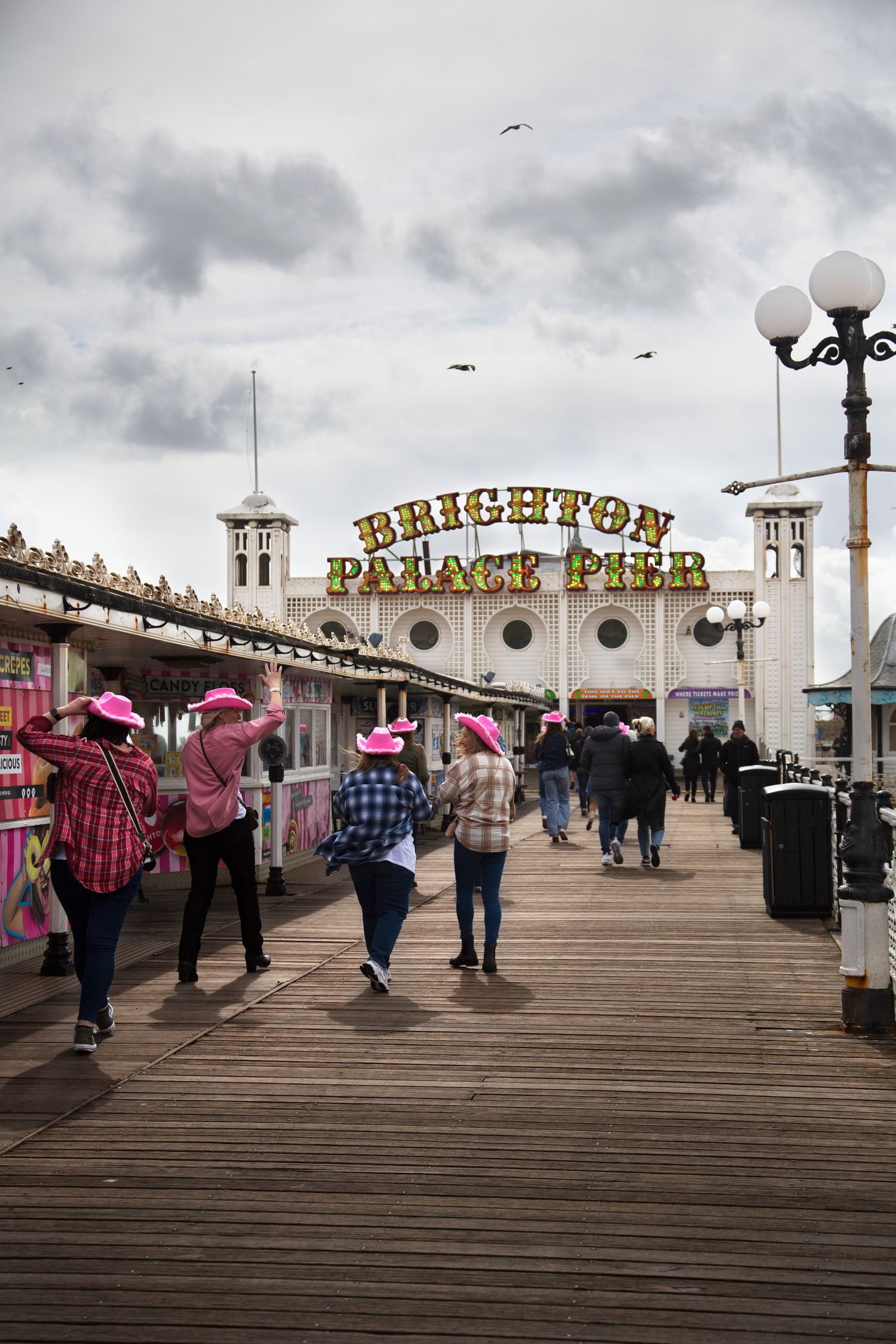 Brighton Palace Pier entrance with ornate signage and vintage lampposts.
