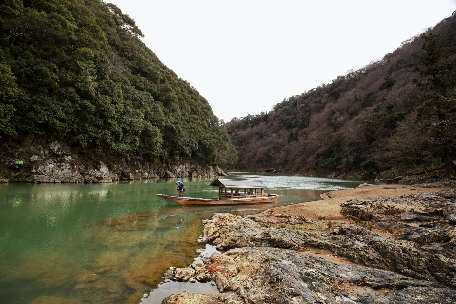 Scenic mountain gorge with emerald green water surrounded by forested slopes.