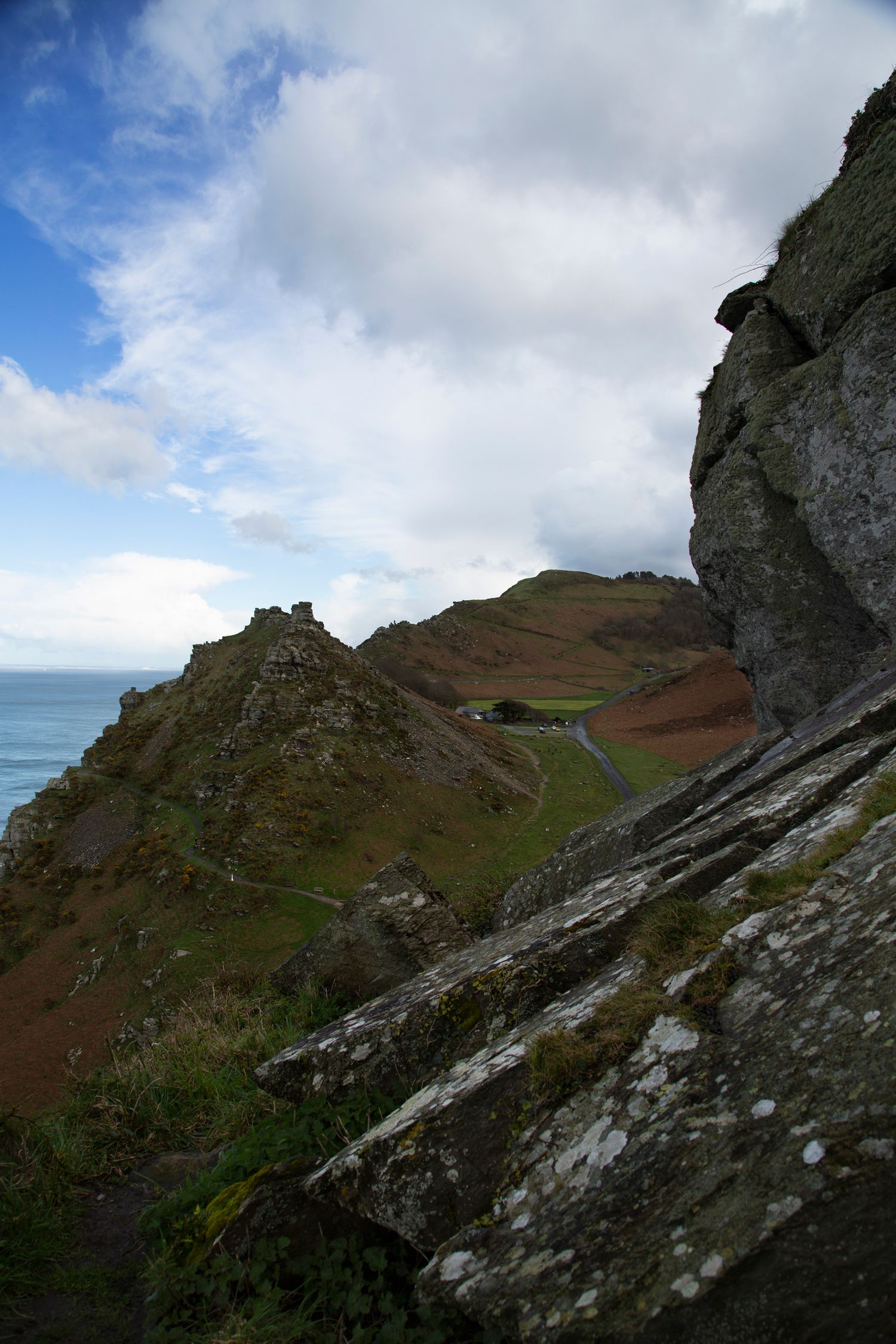 Rocky cliffside terrain with dramatic views of the coastline and blue ocean waters.