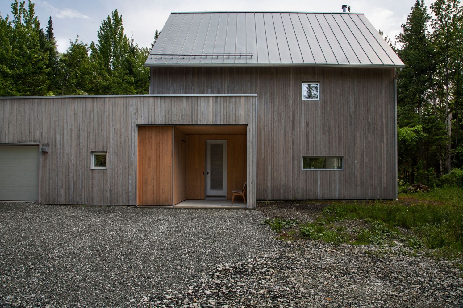 Grey wooden building exterior with gravel ground and forest backdrop in multiple sequential views.