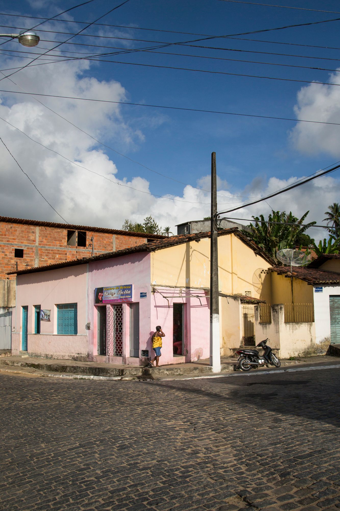 Colorful pastel houses line a cobblestone street in a quiet neighborhood.