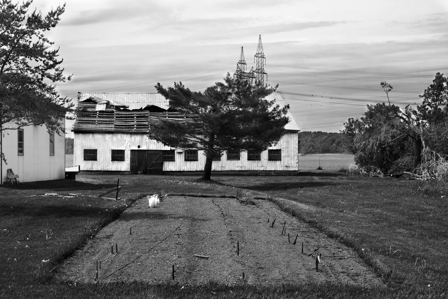 A black and white panoramic view shows a rural church building and cemetery on a hillside with scattered trees.