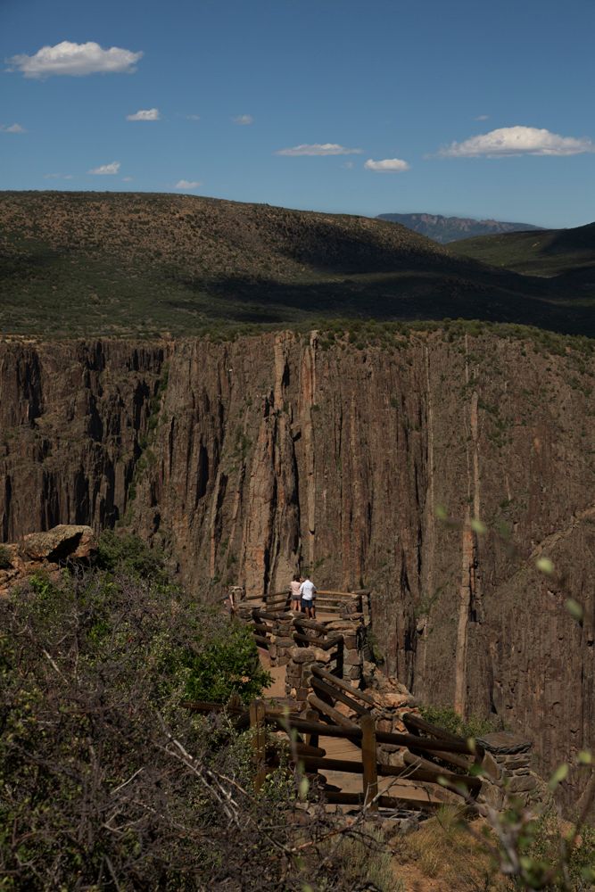 Towering cliff faces and deep canyon walls in a rugged mountain landscape.
