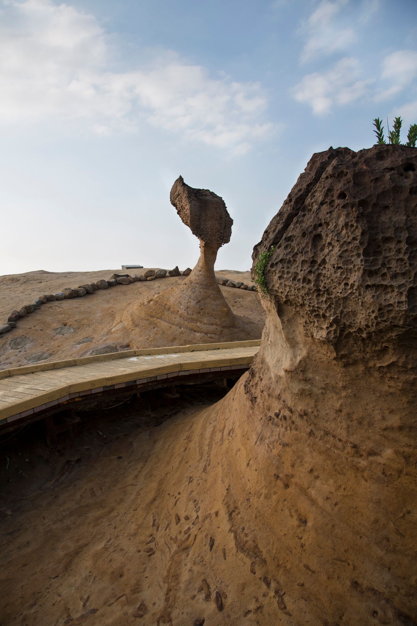 Natural rock formations creating mushroom-shaped structures against a blue sky.