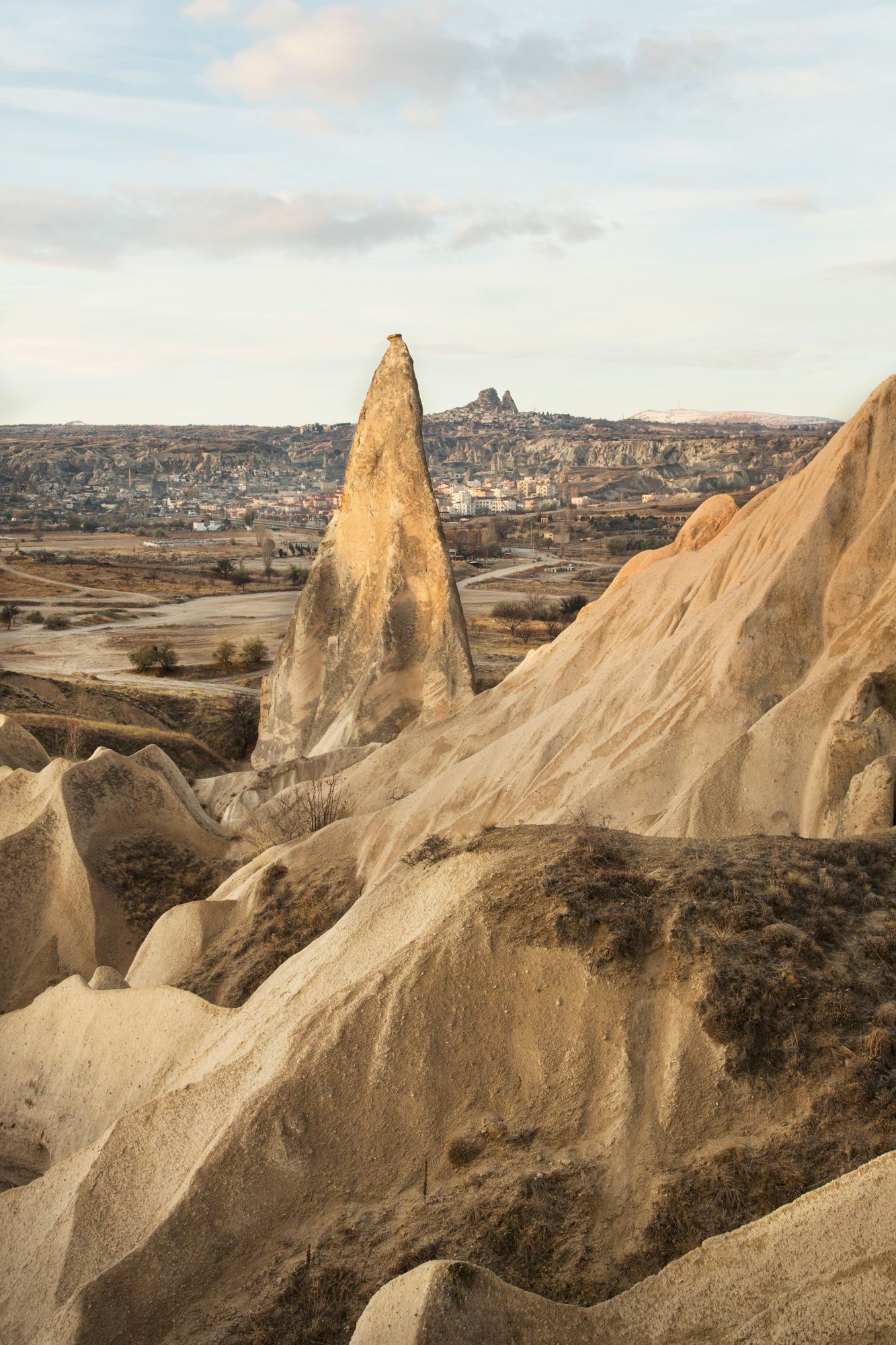 Dramatic limestone pinnacle rises above Cappadocia's otherworldly valley landscape.