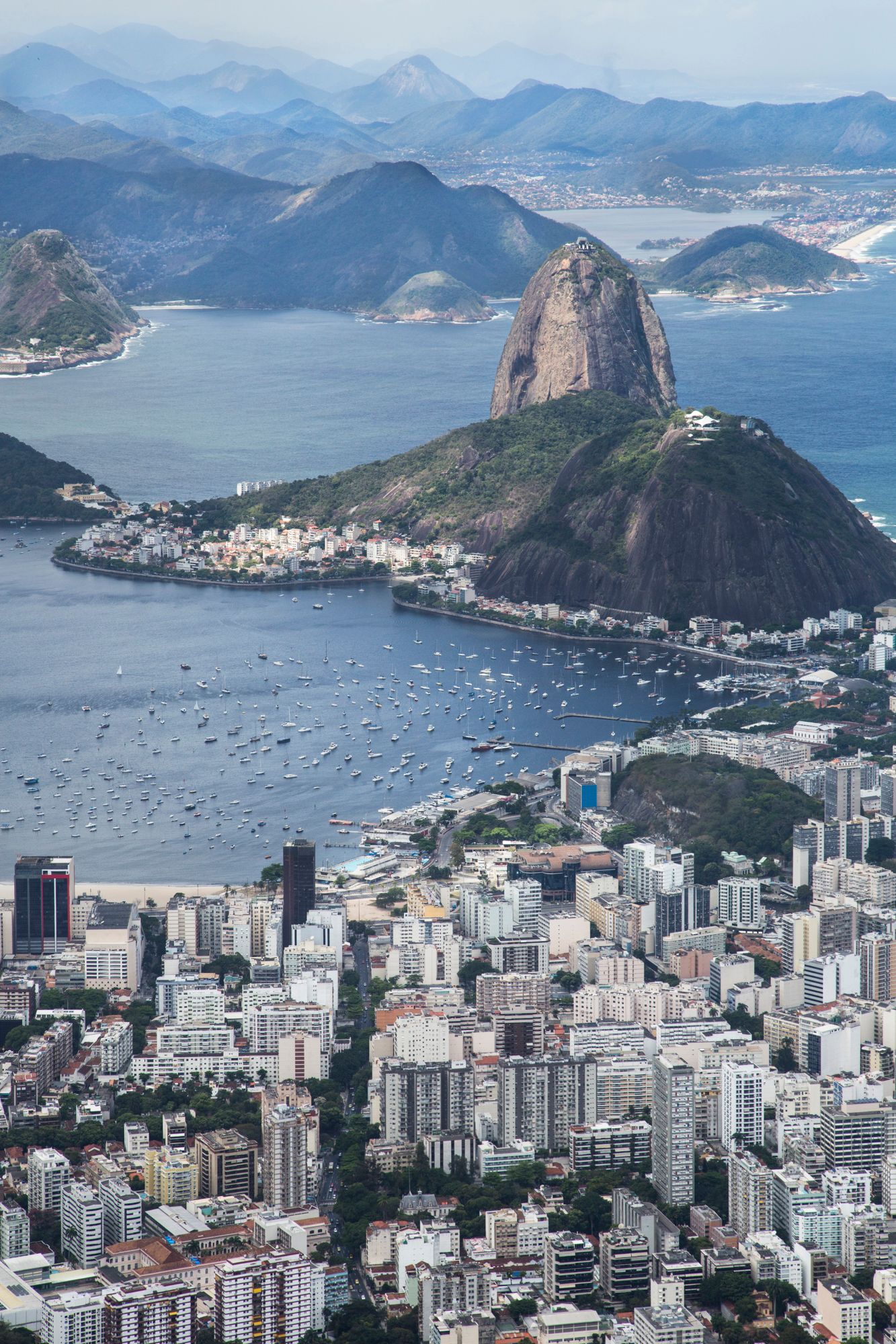 Aerial view of Rio de Janeiro showing Sugarloaf Mountain and dense urban development along the coastline.