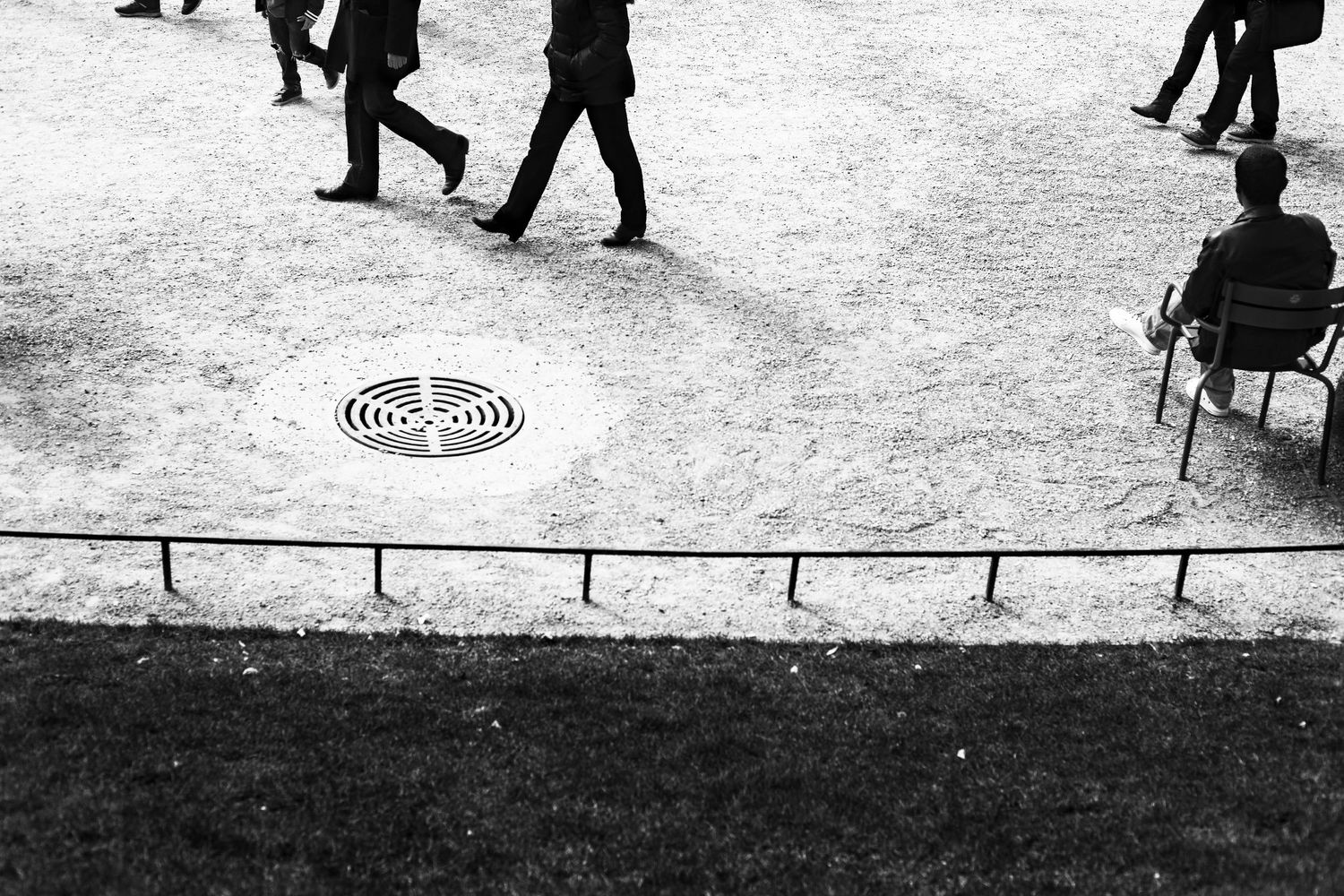 People walking across a snowy park ground in black and white.