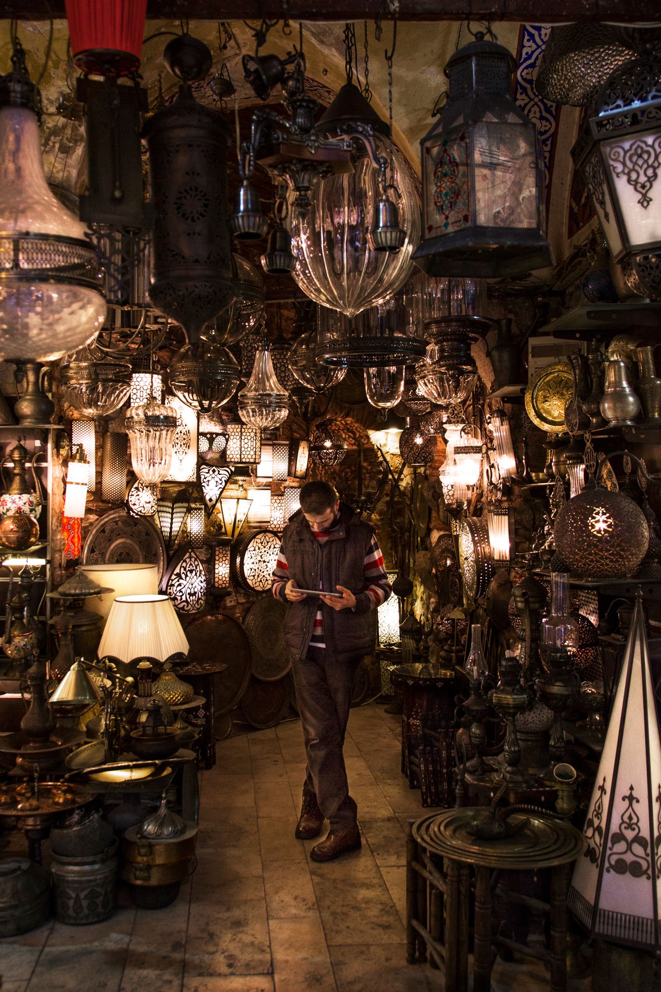 Antique shop interior filled with ornate hanging lamps and chandeliers creating a magical atmosphere.