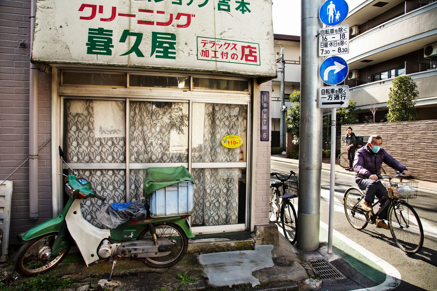 Row of small local shops and businesses along a quiet Japanese street.