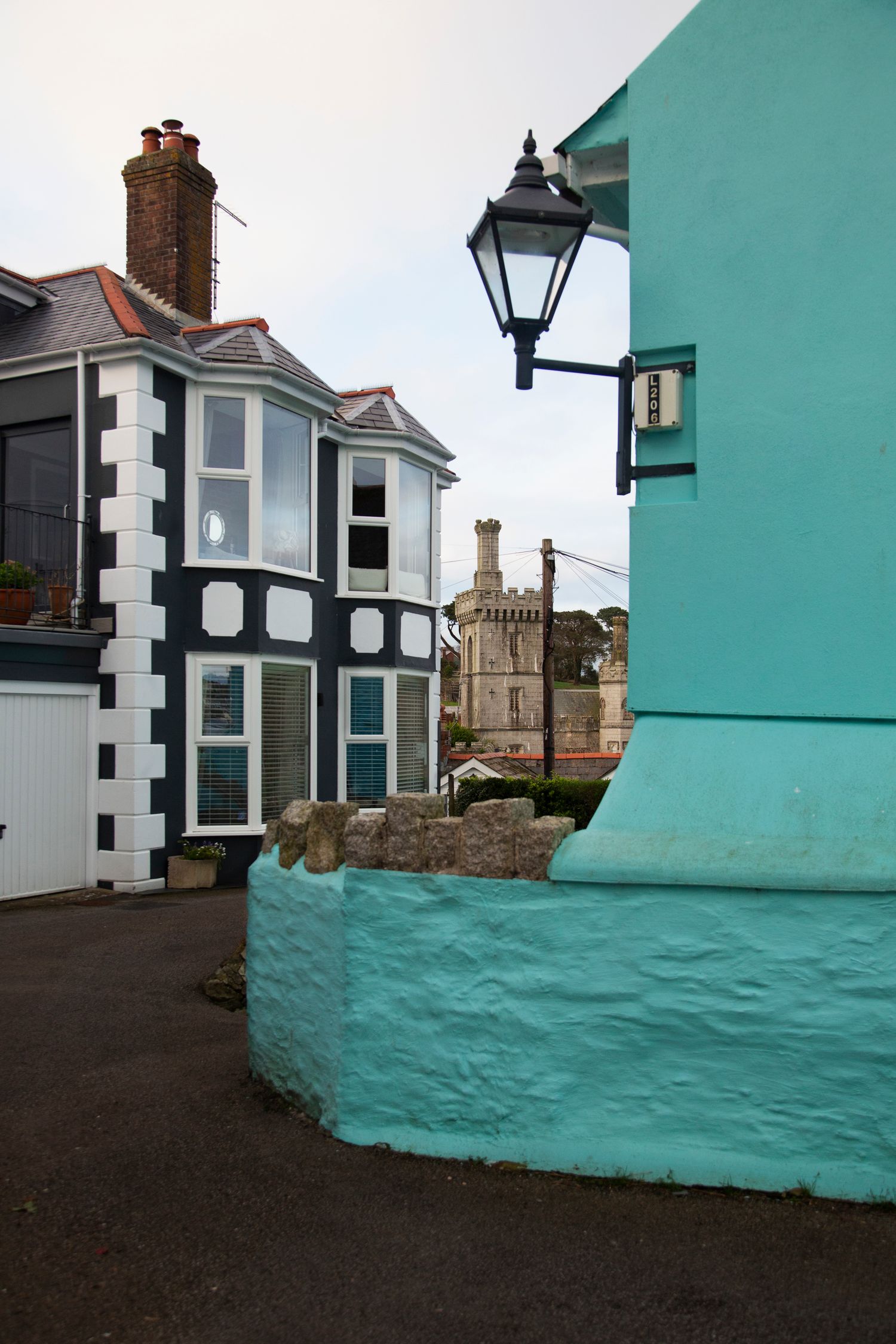 Colorful corner building with turquoise walls and black-and-white architectural details.