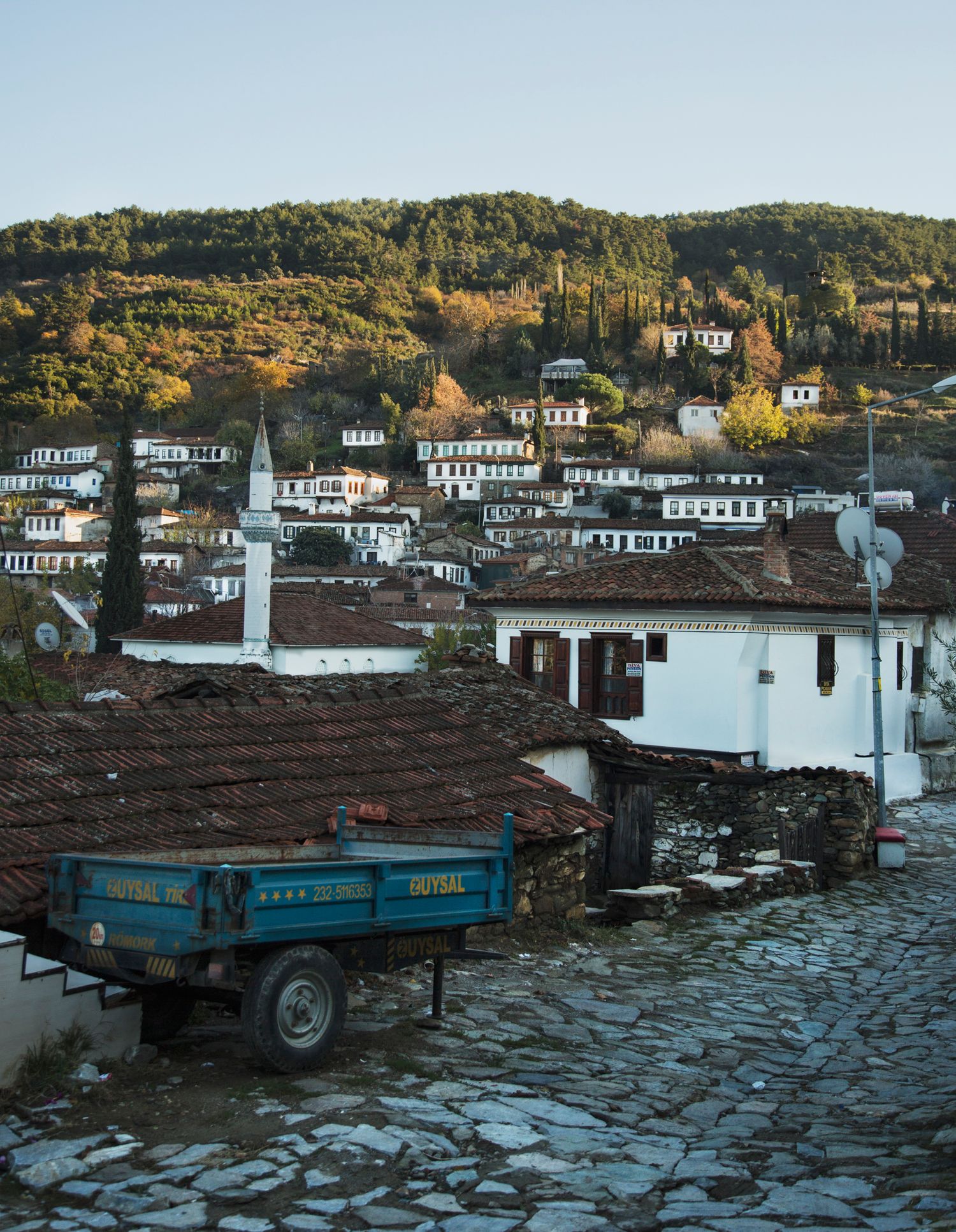 Traditional Turkish village with white houses and red tile roofs nestled on a hillside.