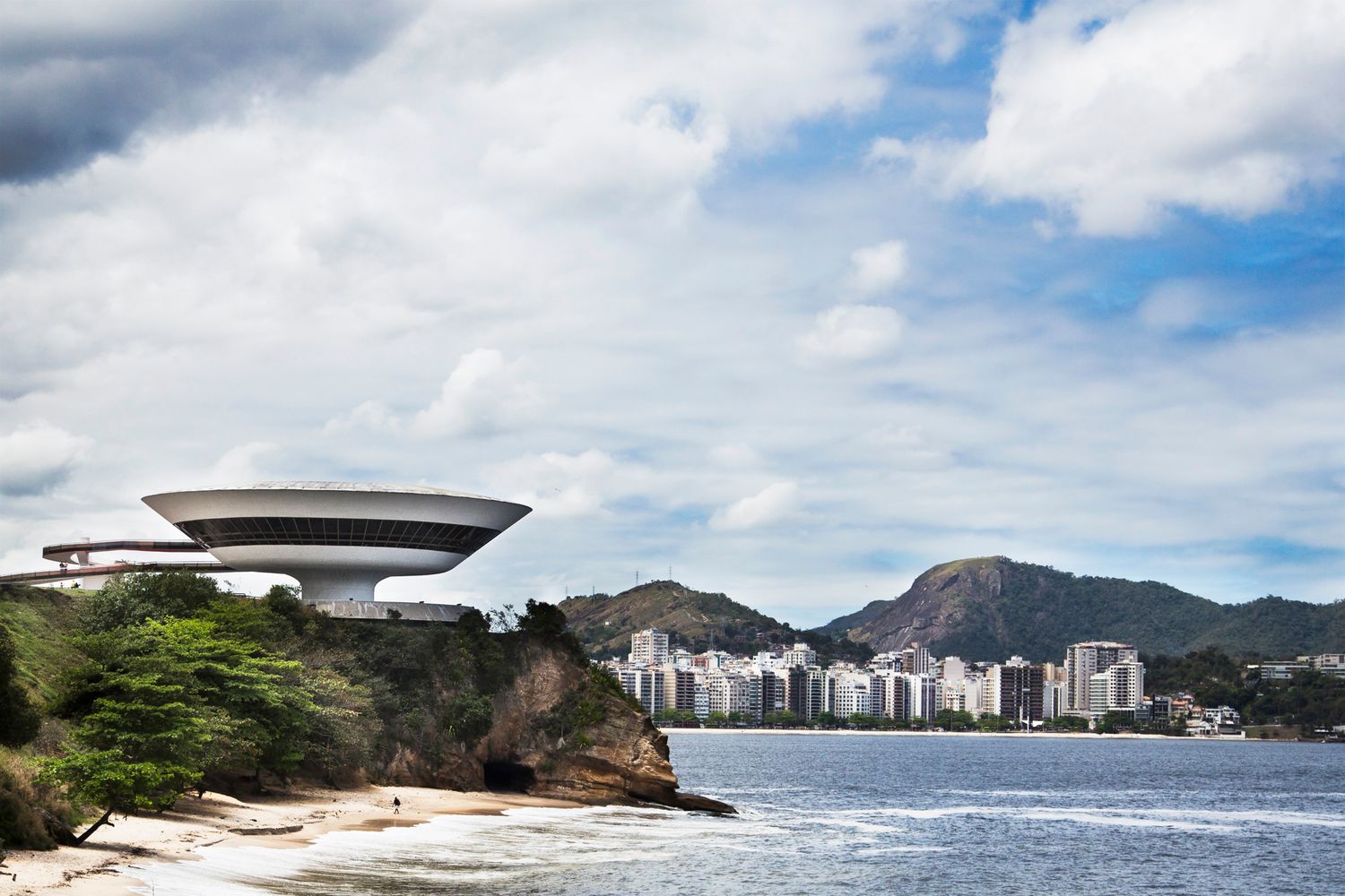 Aerial panoramic view of a modern city skyline with mountains and coastline in Rio de Janeiro.