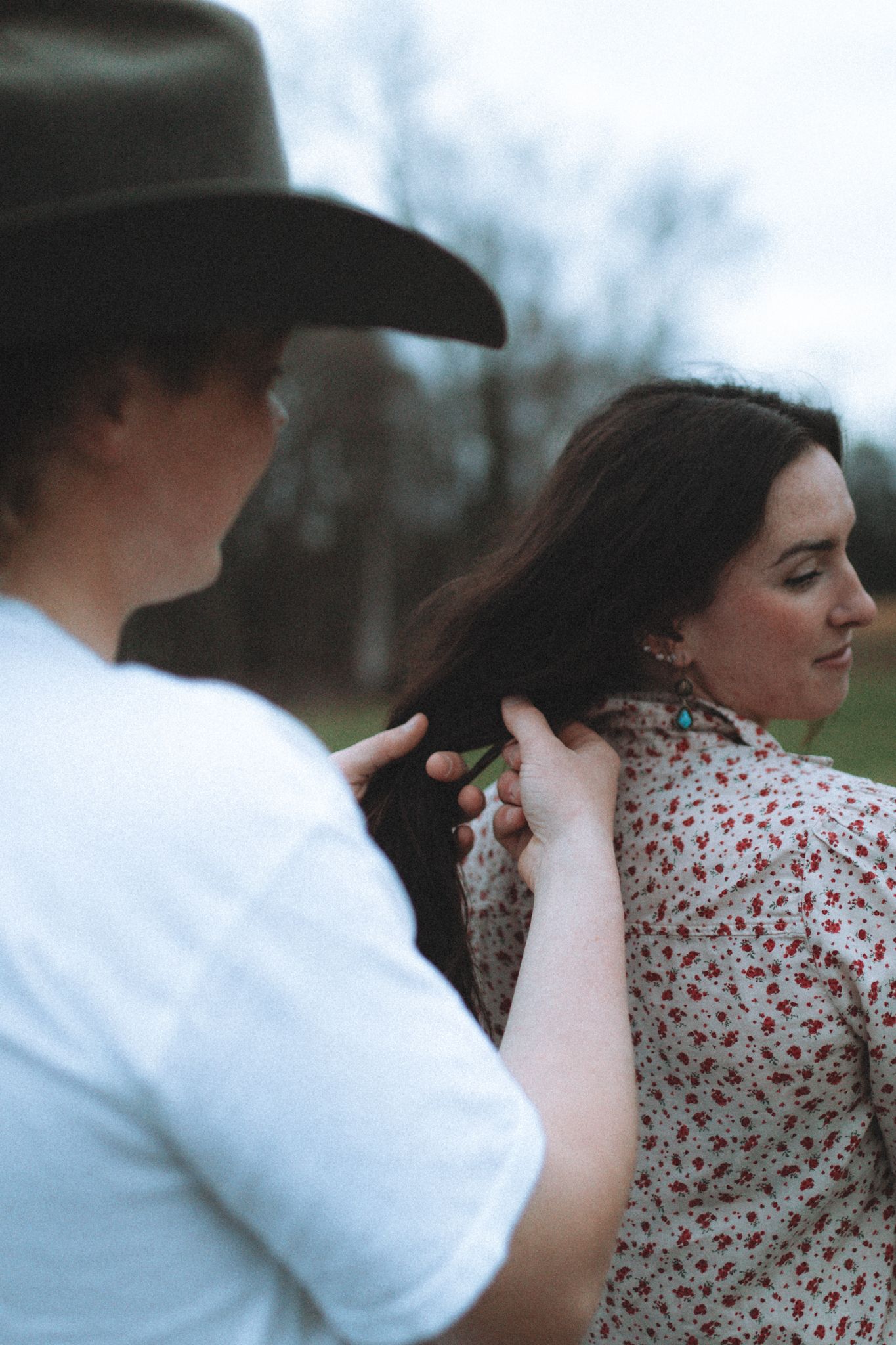 Couple shares tender moments in a field during an outdoor photoshoot.