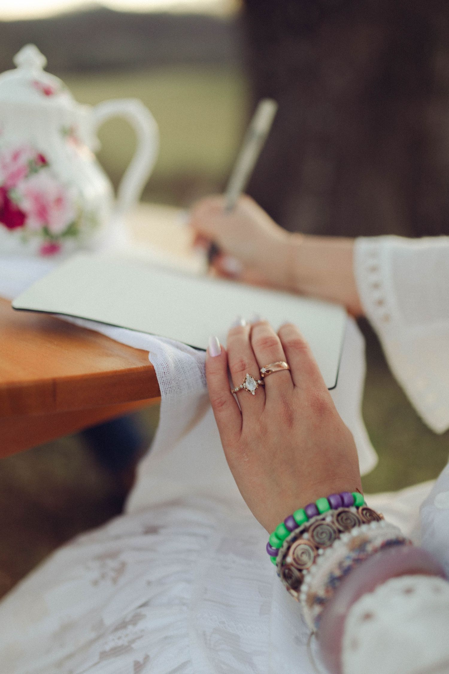 Close-up of hands holding a teacup showing an engagement ring.