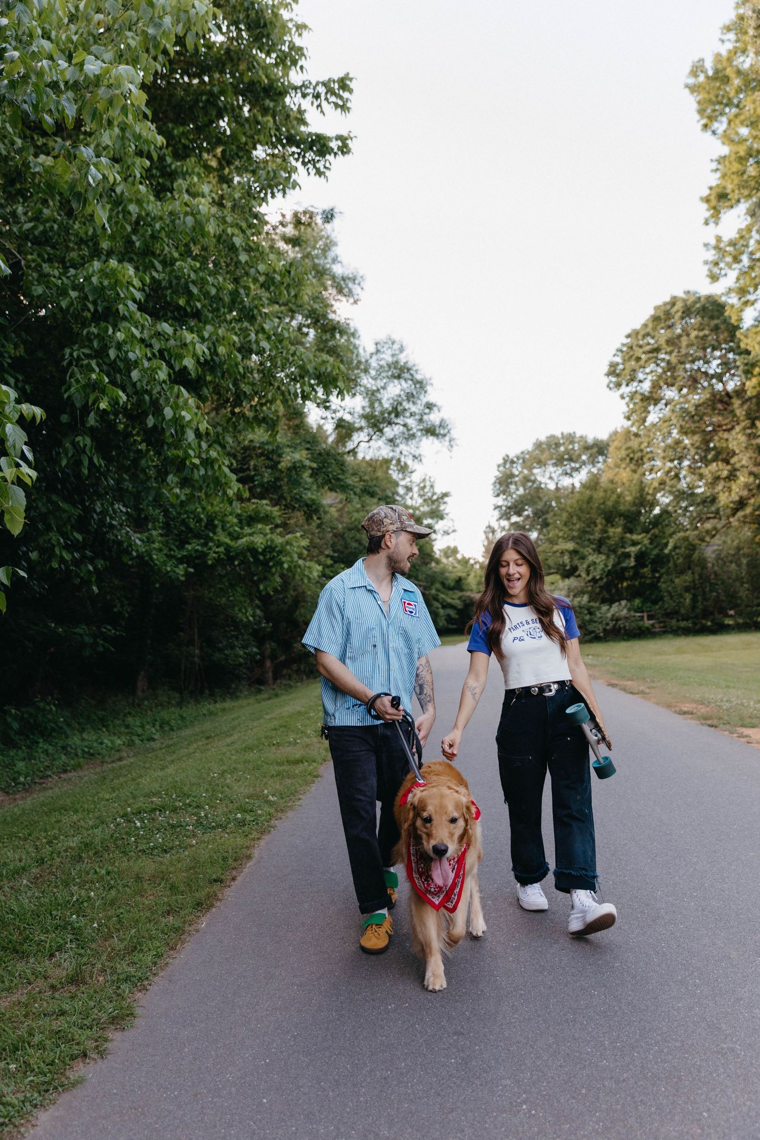 Group walking on paved path with golden retriever dog.