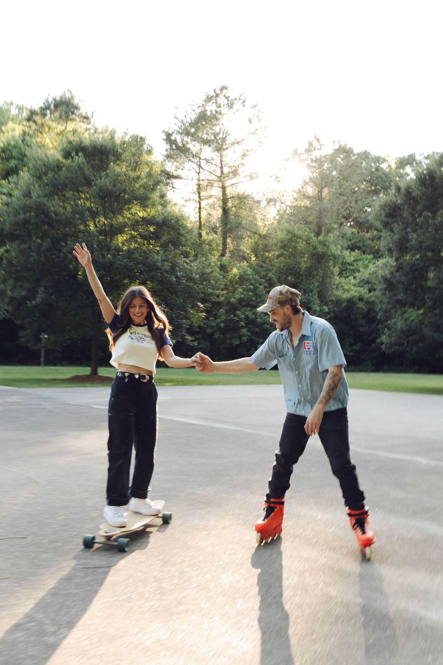 Two skateboarding friends perform a synchronized trick on the pavement while skating together at sunset.
