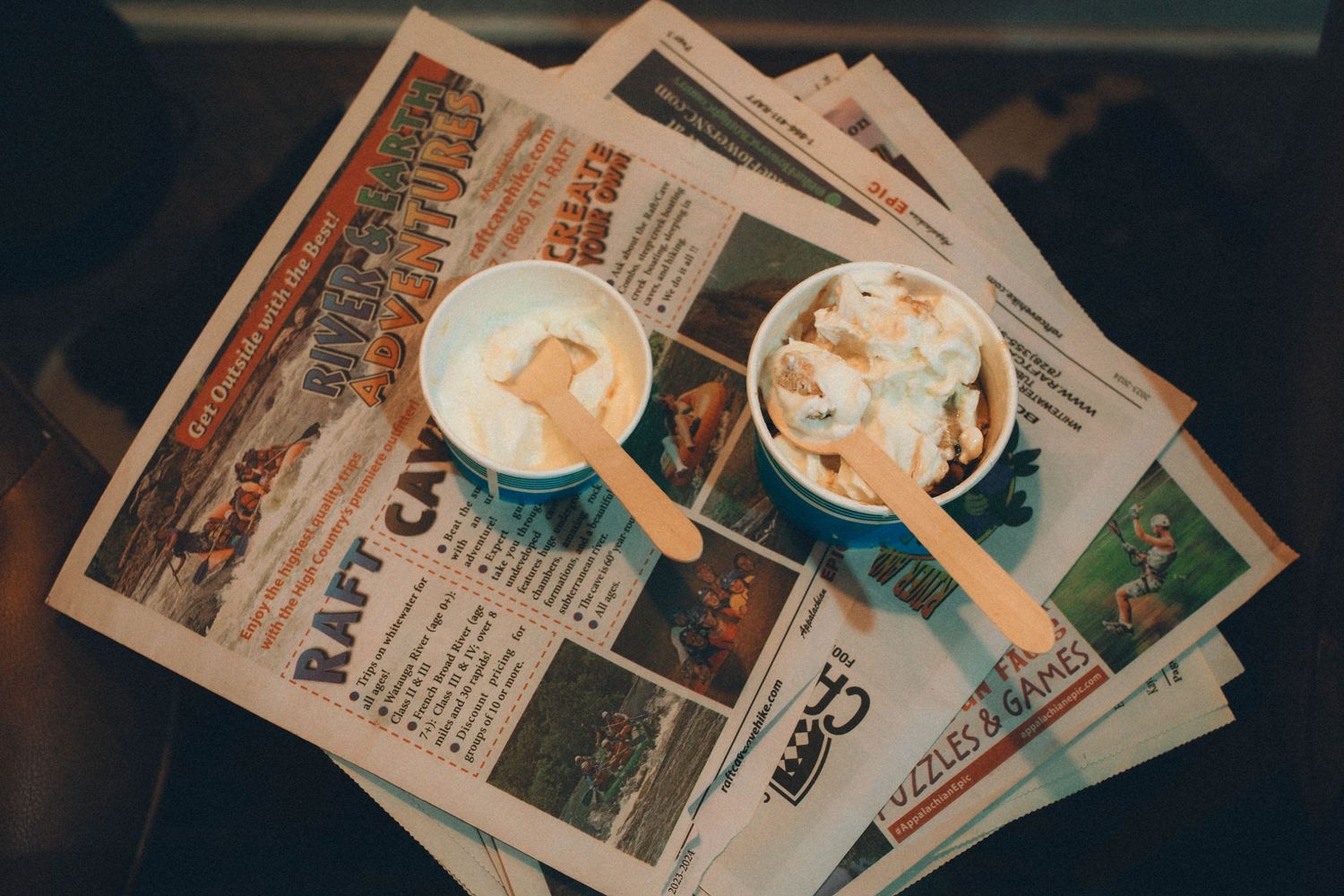 Collection of vintage magazines or newspapers spread out on a dark surface.
