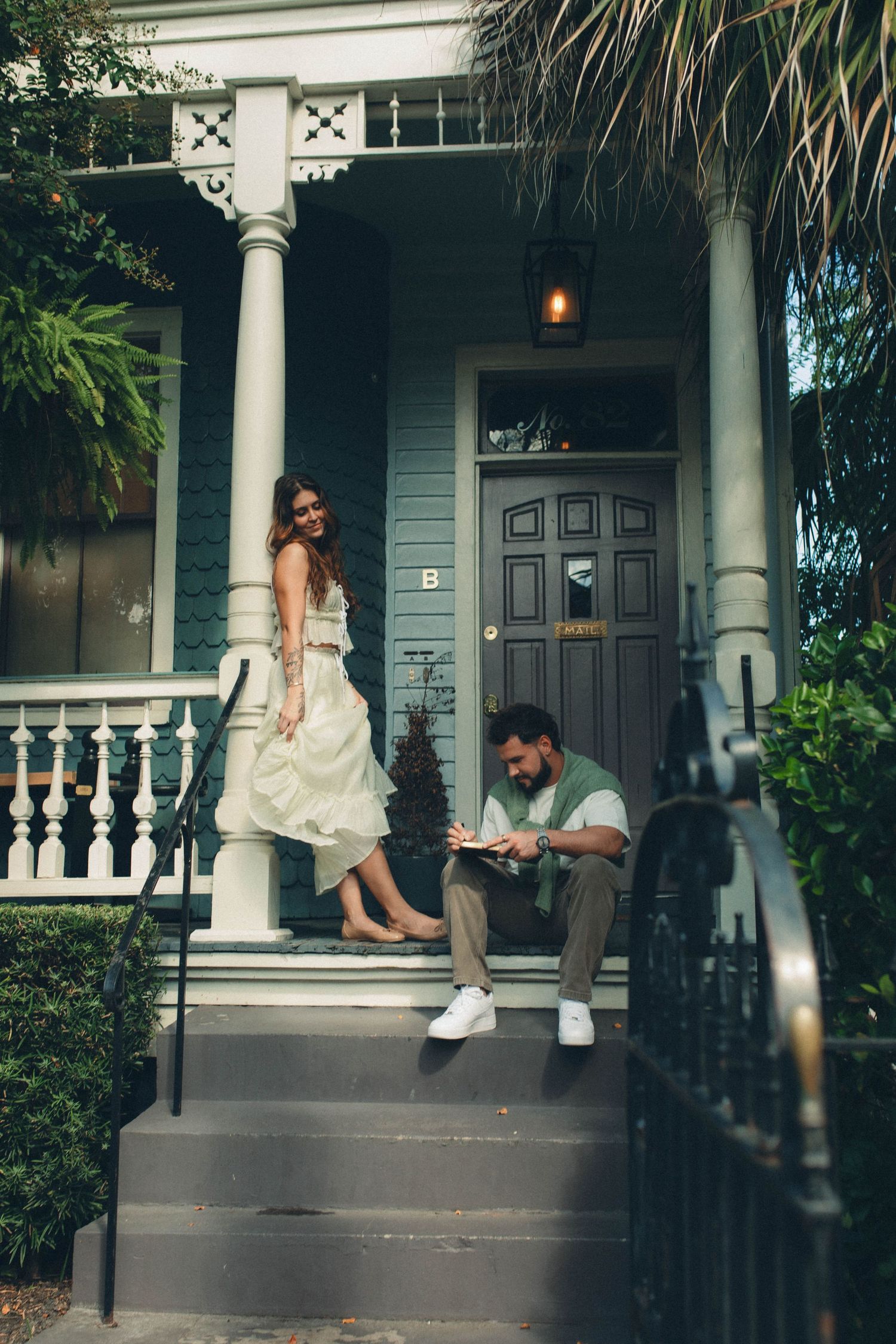 A relaxing scene on a classic southern porch with white columns and railings.