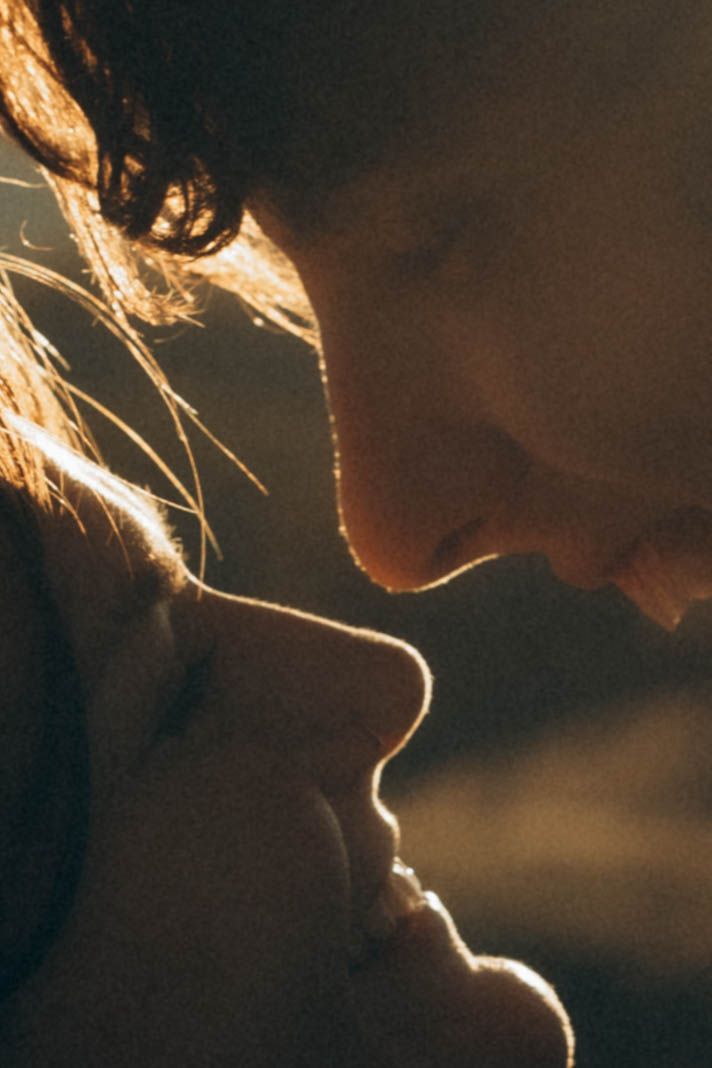 A silhouette portrait backlit with warm golden light creating a romantic atmosphere.