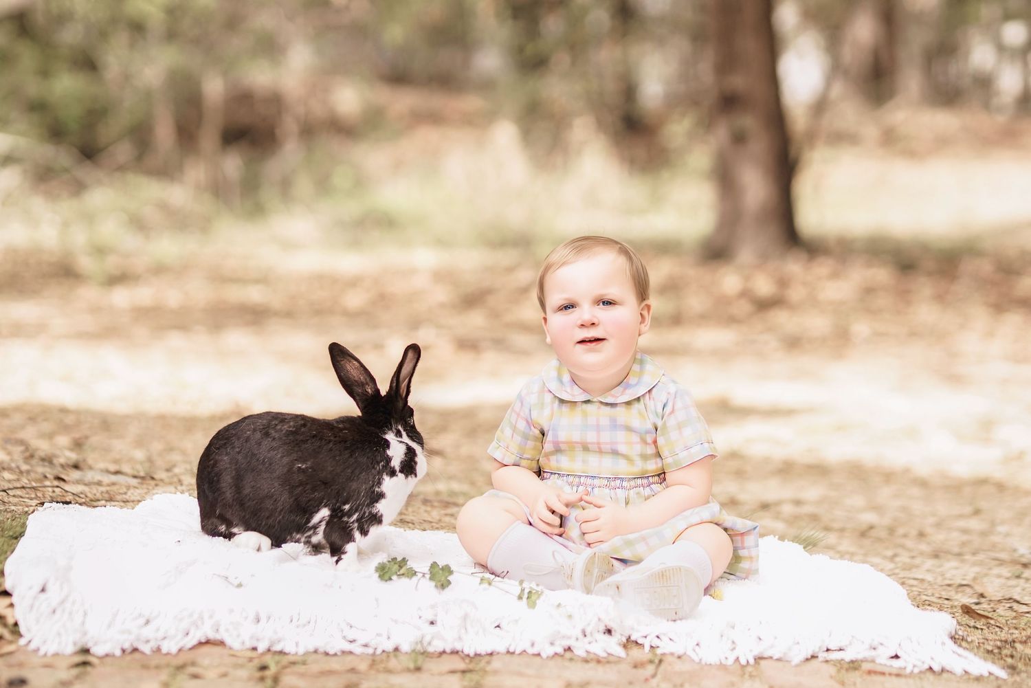 Child interacting with bunny during portrait session in South Carolina, soft natural light, whimsical heirloom style