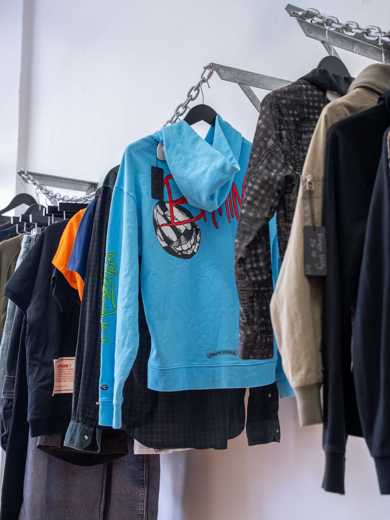 Row of athletic wear and sports clothing hanging on retail display racks.