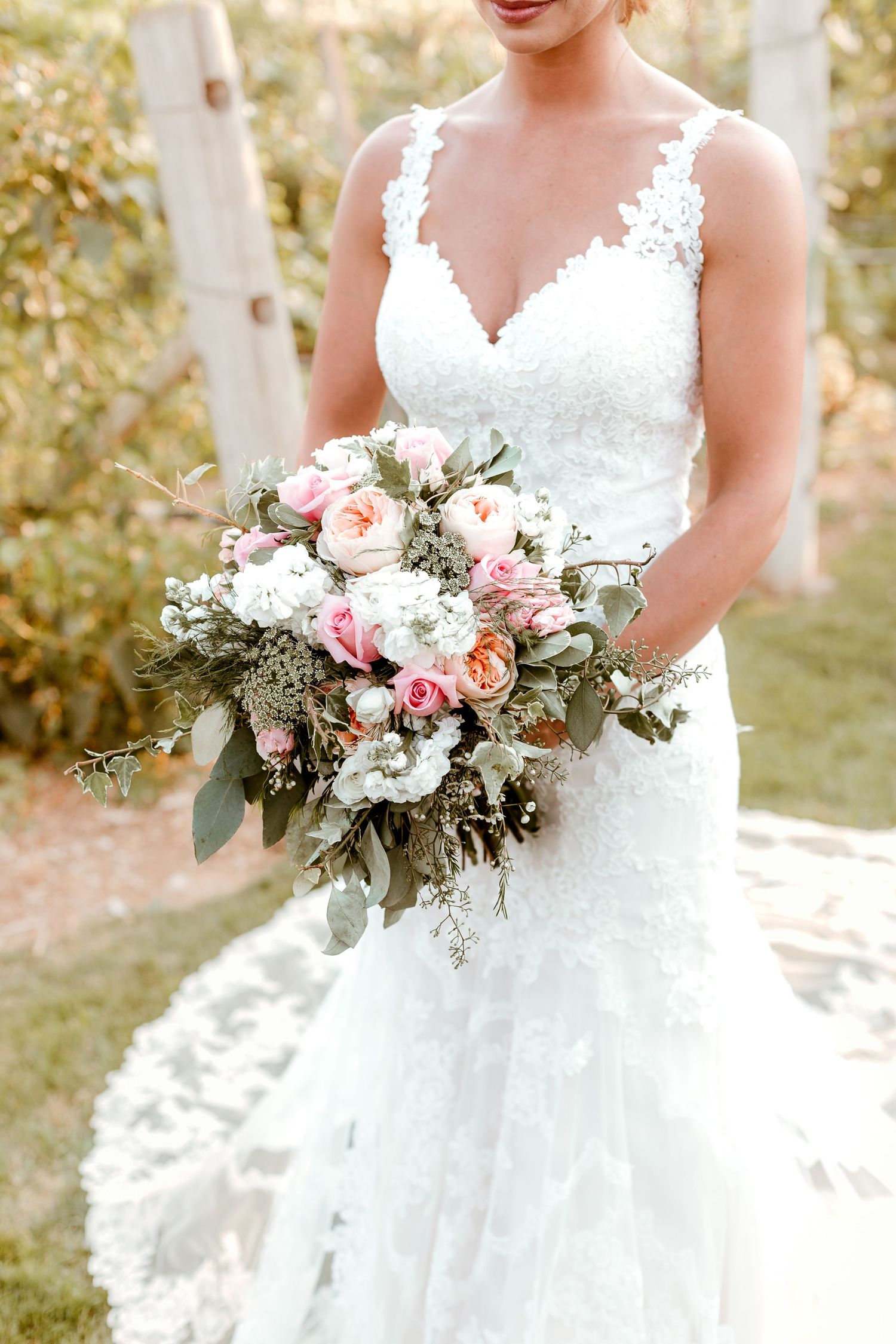 Dreamy floral bouquet over flowing with white, peach and pink roses.
