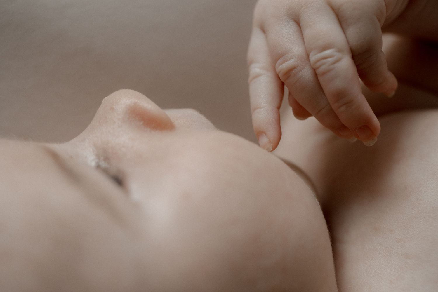Extreme close-up of gentle touch and tender moment with newborn.