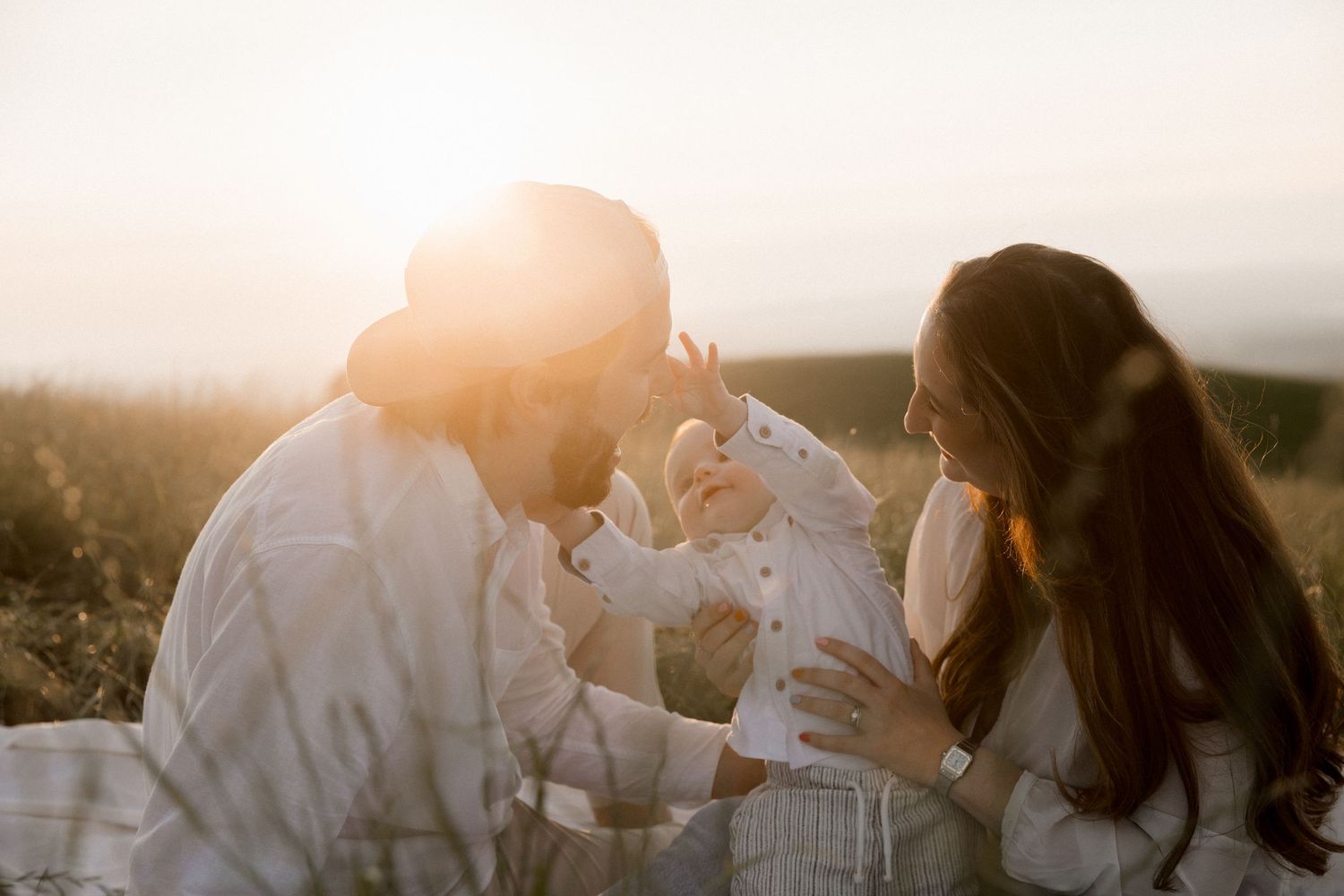 Family sharing intimate moment during golden hour in outdoor setting.