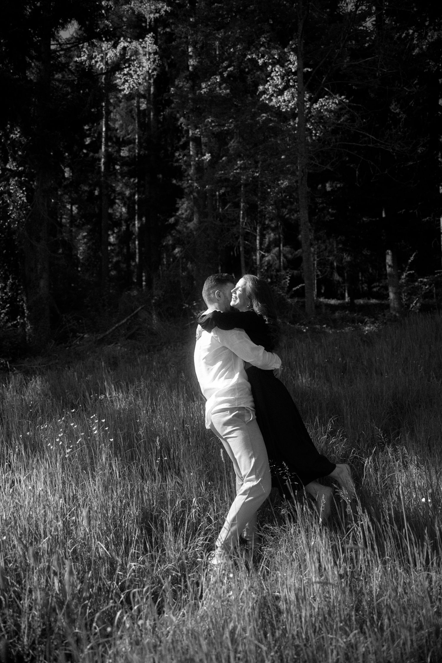 A sequence of black and white photos showing a figure falling dramatically in tall grass at sunset.