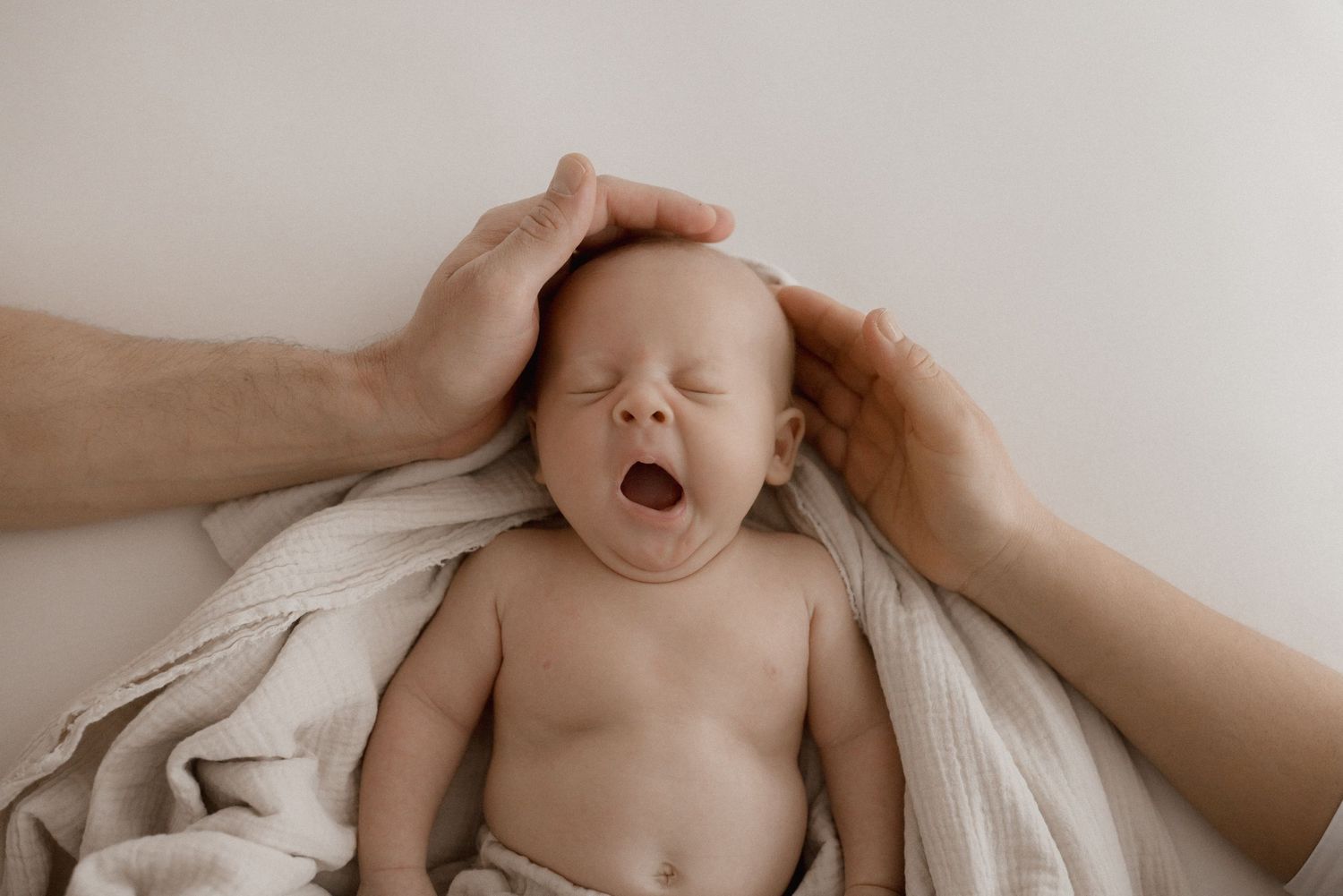Tender moment captured in soft natural lighting against white background.