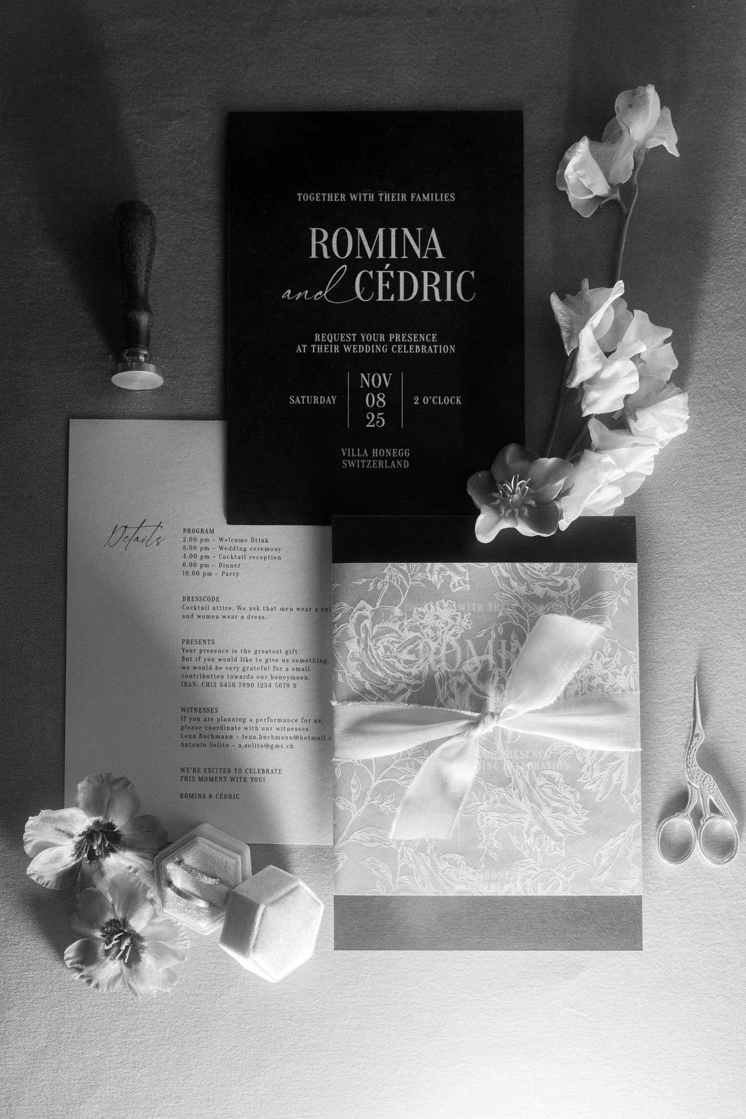 Elegant black and white wedding invitation suite for Romina and Cedric, featuring floral accents, ribbon bow, and wax seal.