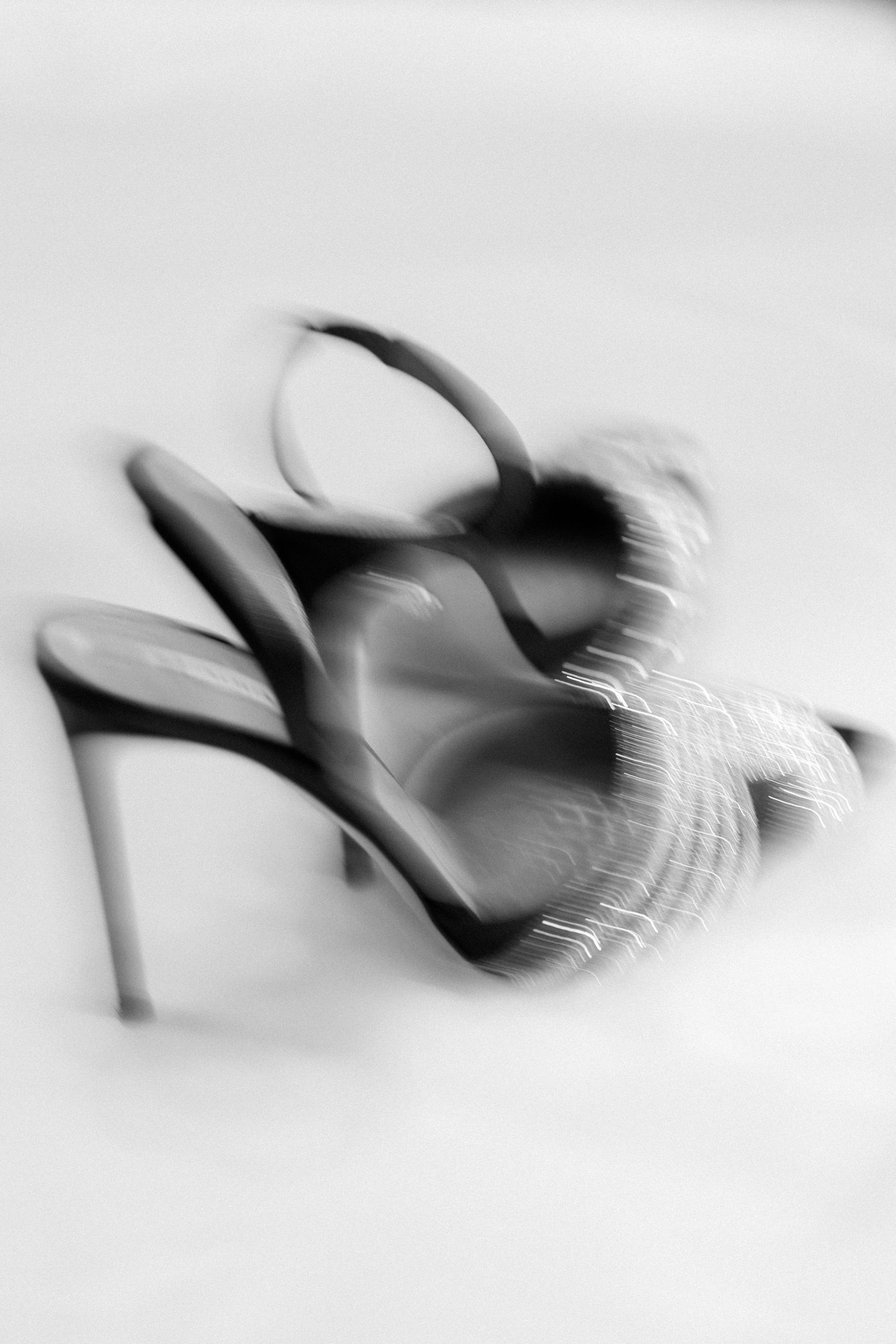 Abstract motion blur photograph of dancing figures in black and white.