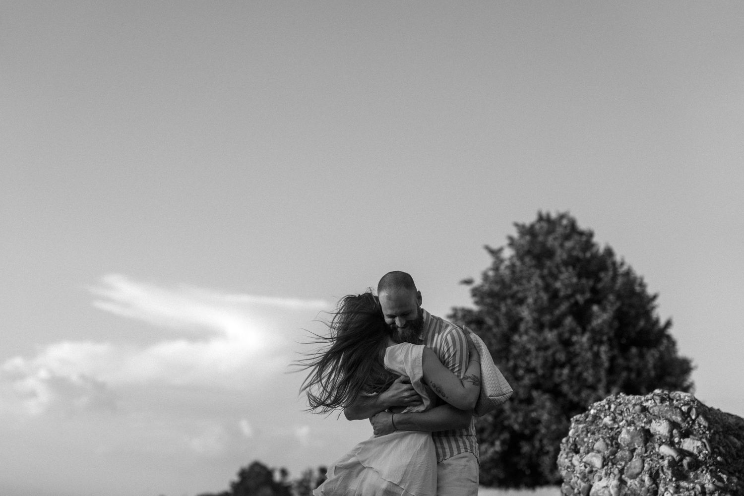 Black and white photo montage showing intimate moments between people embracing outdoors and indoors.