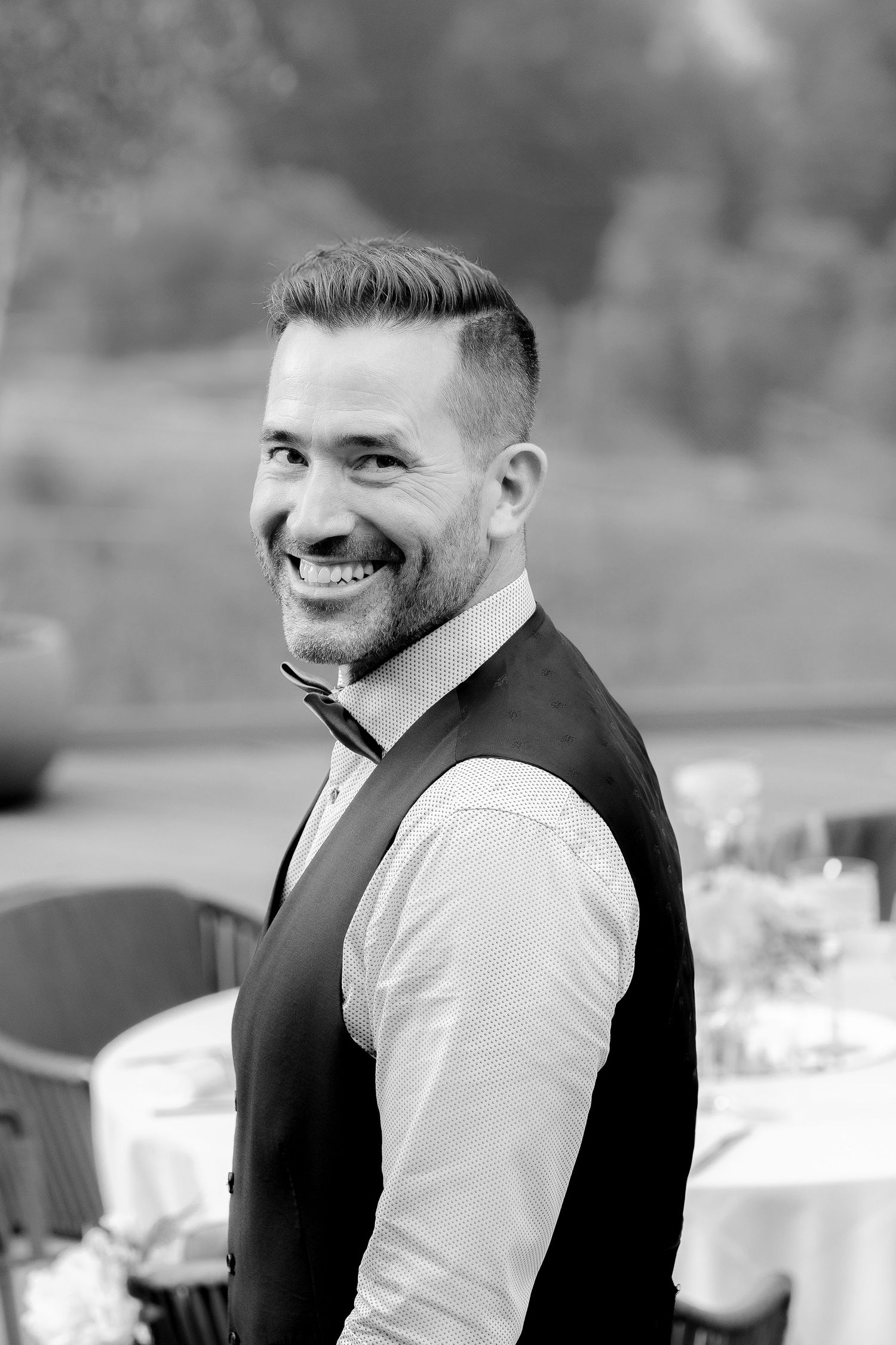 Black and white photo sequence showing a person in a white shirt and dark vest smiling and looking to the side.